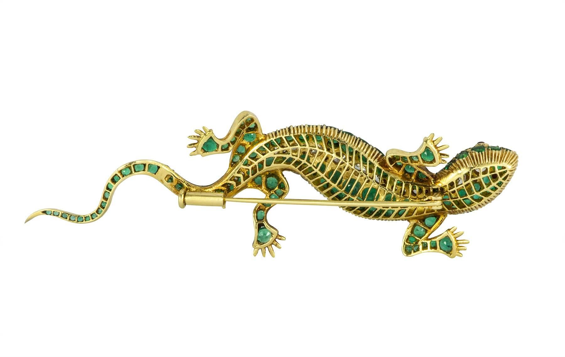Emerald and diamond 18k yellow gold lizard brooch with ruby eyes.  The lizard contains an estimated 6.26cts in round cut emeralds, with an estimated 2.10cts in round brilliant diamonds.  The ruby eyes are approximately .10cts total.  The color of