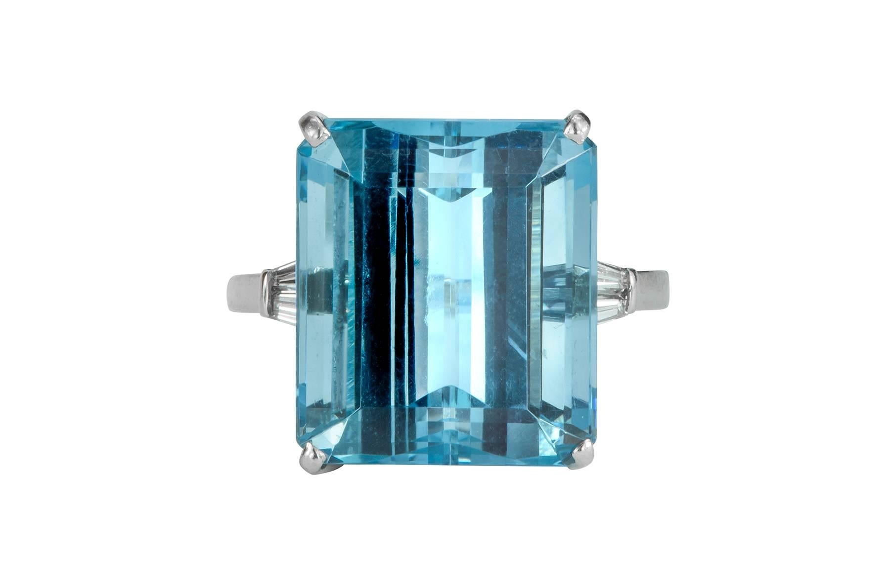 This is an amazing color aquamarine and diamond ring set in platinum.  The aquamarine is set in a four prong basket, with two diamond tapered baguettes on either side.  The aquamarine is estimated to be 12.88cts, with four diamonds weighing 0.16cts