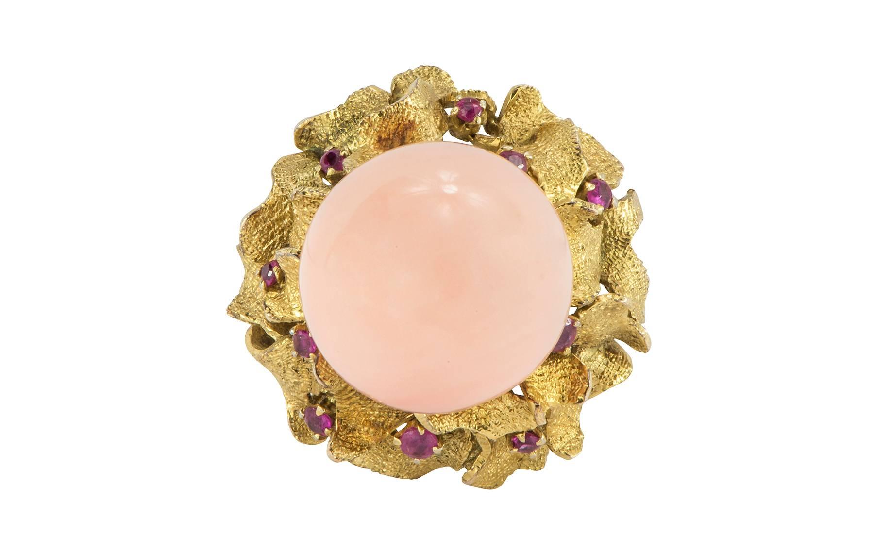 A round angel skin coral  and ruby 14k yellow gold ring.  The 13.80mm coral is set on a post with textured waves of gold and rubies surrounding.  

Hallmark:  14K
Currently a size:  7.00