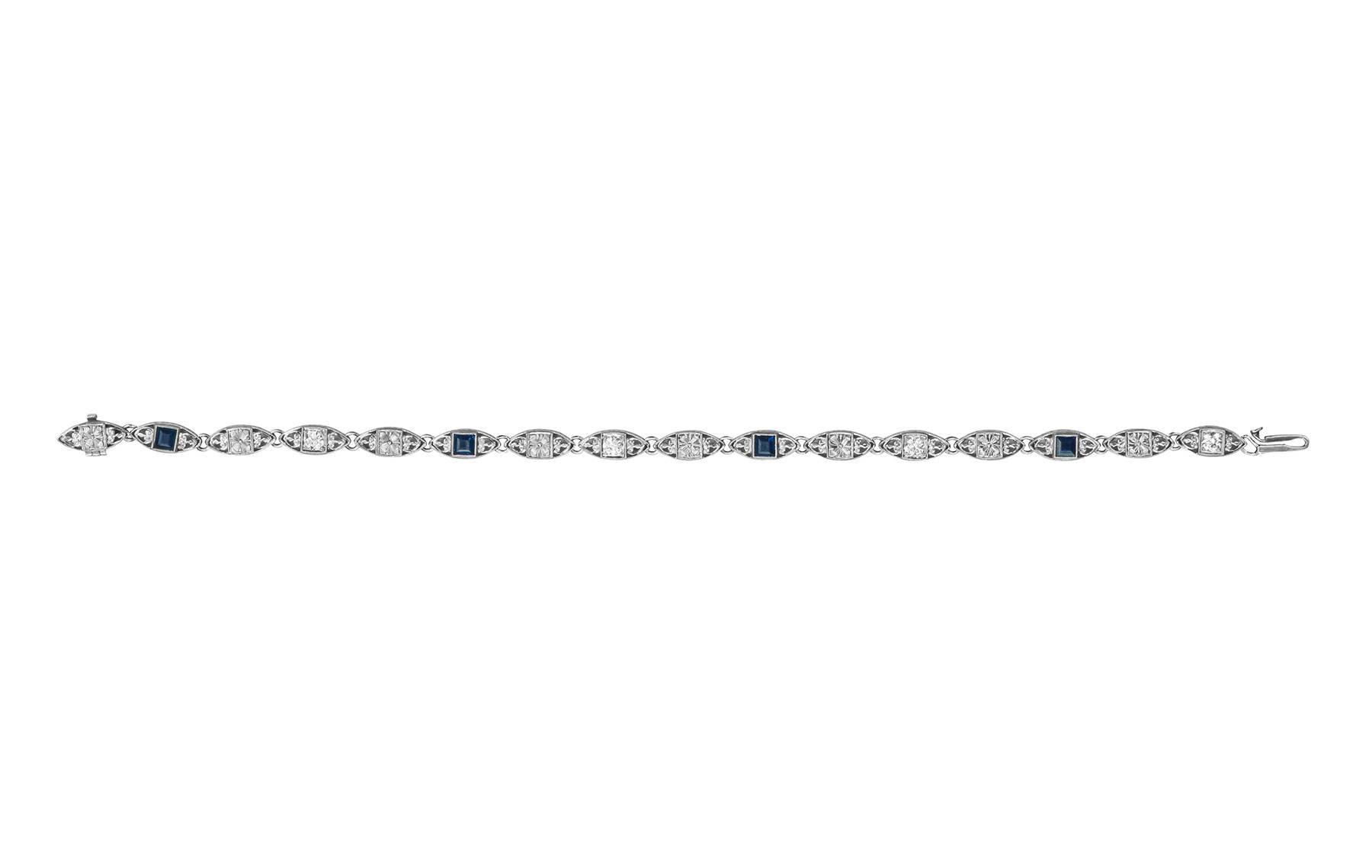 A diamond and sapphire bracelet, made in platinum by Tiffany & Co.  There are four square cut sapphires, bezel set, weighing 0.80cts, and four round brilliant diamonds weighing 0.40cts.  The remaining links without any gemstones have a floral