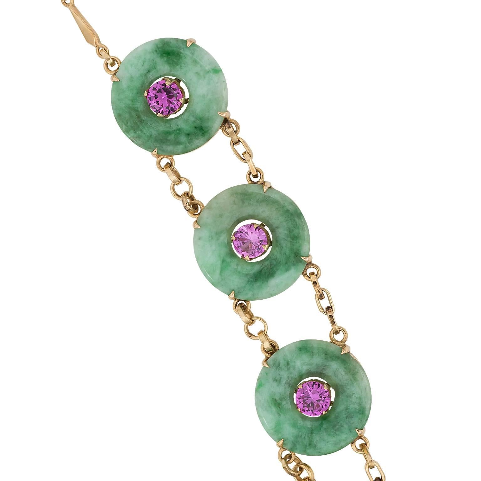 Jade and pink tourmaline 22 karat gold necklace.  The necklace is made up of ten carved jade discs with a round cut pink tourmaline in the center of each.  The discs are linked by a double linked chain.

Length:  18.50 inches  