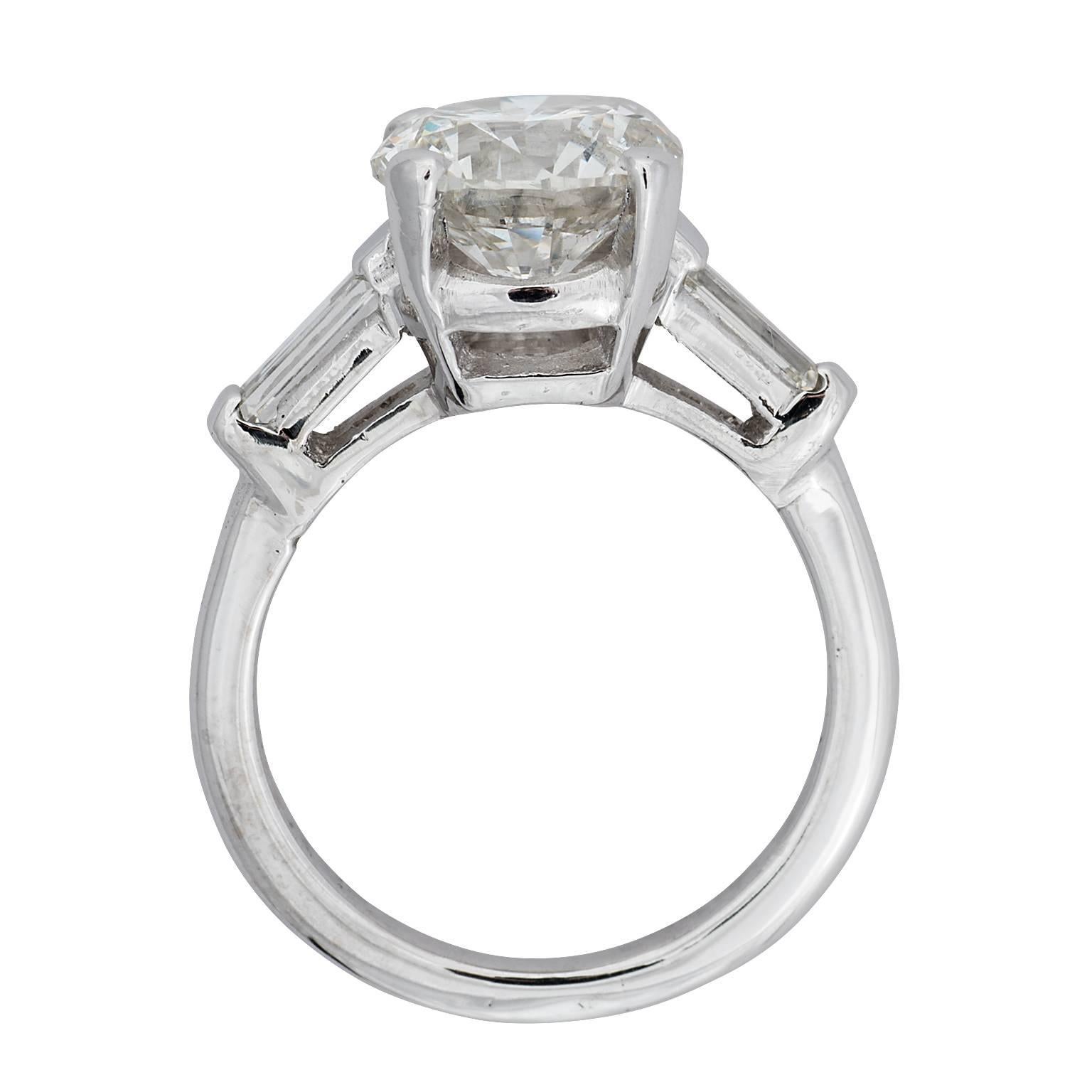 3.11 carat round brilliant diamond and baguette diamond platinum ring.  The 3.11 carat round brilliant is set in a four prong basket, graded by GIA as a J color, I1 clarity.  the baguette diamonds have a total weight of 0.40 carats and are graded as