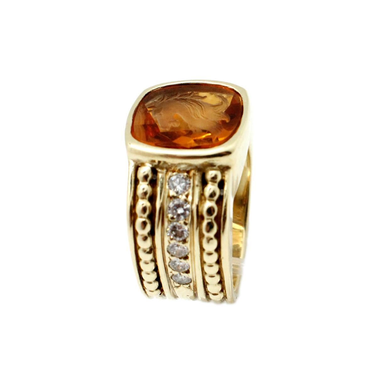 This beautiful ring is handcrafted in 18kt yellow gold by well known New York based designer Judith Ripka. It is designed with one large intaglio carved citrine powerful horse as the bold focal point of the ring. The ring also features 12 stunning