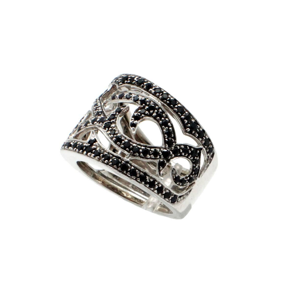 This fun band is made in 18k white gold, and it is set with several round black sapphires. The band measures 15mm wide, and it weighs 10.59 grams. The ring is a size 5.25.