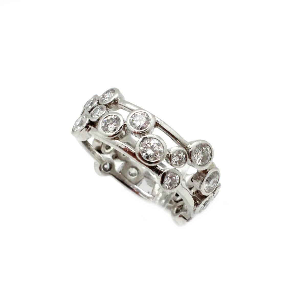 The band style ring is crafted in platinum by designer Tiffany & Co. It features bezel set, round brilliant-cut diamonds all around. The diamonds have a total weight of 1.60ct and are graded G in color and VS in clarity. The ring measures 4.5mm wide