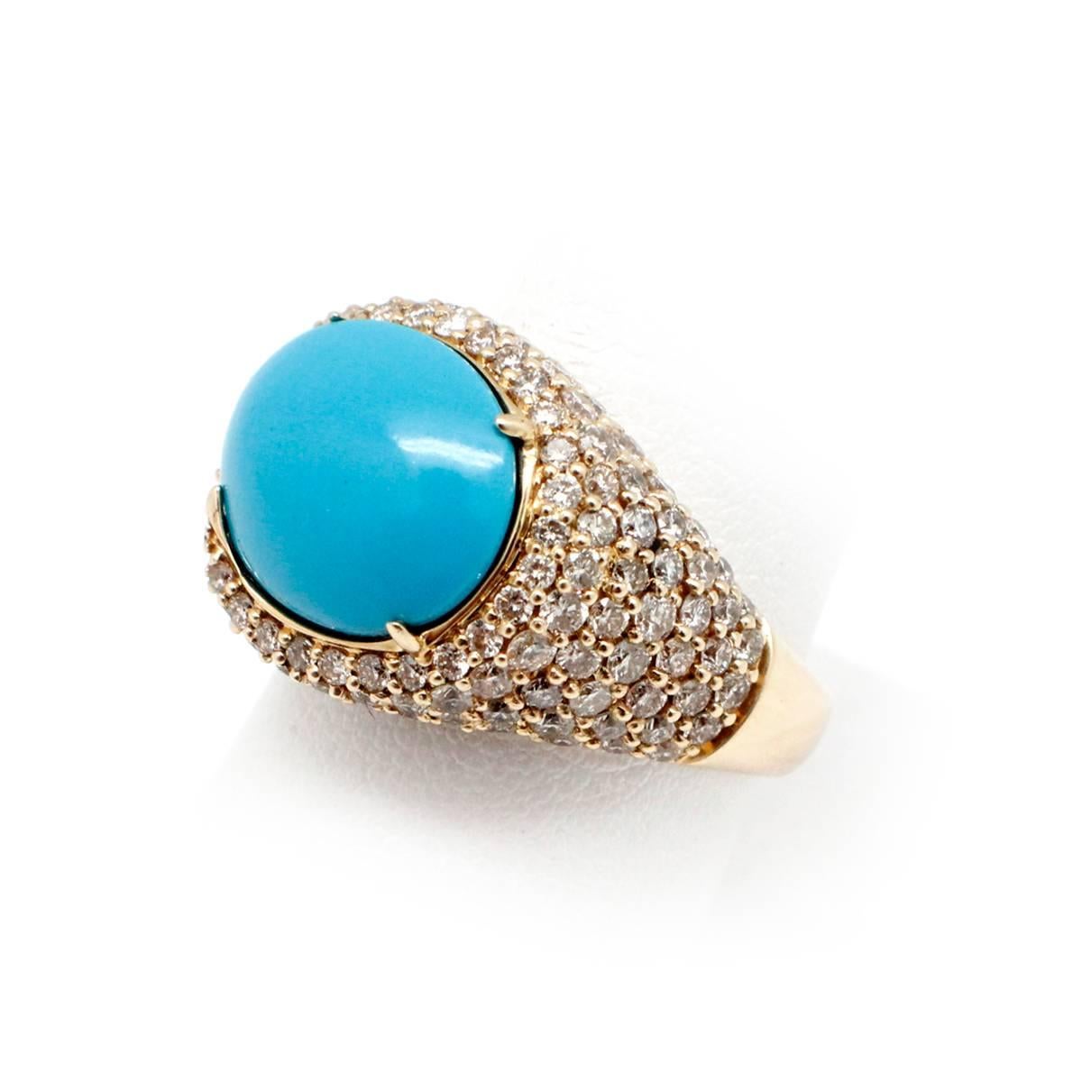 This ring is made in 14k yellow gold. It features a turquoise stone at its center. Accenting the turquoise are 150 round brilliant, pave-set diamonds. The diamonds have a total weight of 2.25ct. The ring measures 16mm at its widest point and weighs