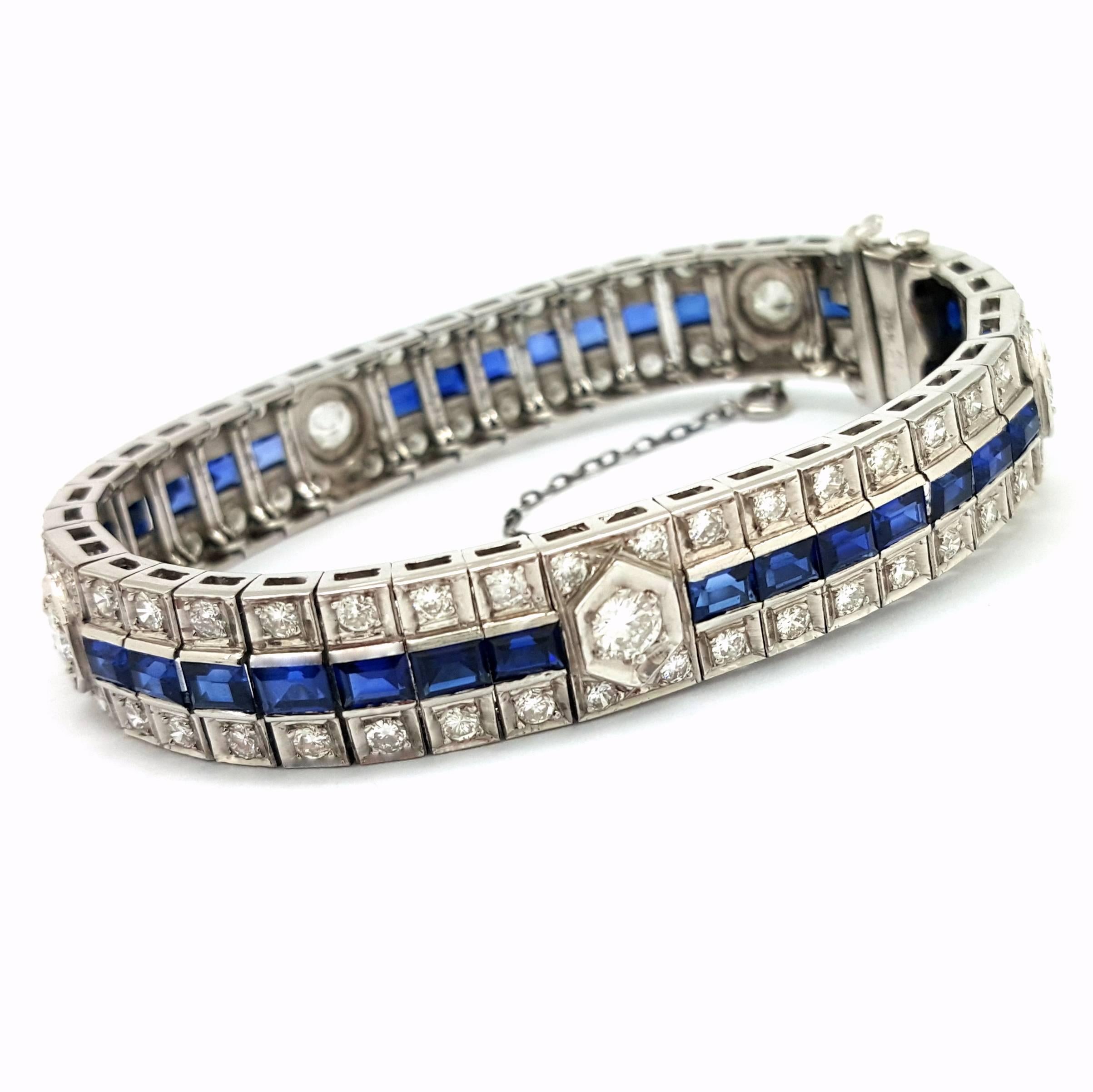 This unique bracelet is crafted in 14k white gold. It is set with 93 round, brilliant-cut diamonds that have a total weigh of 5.60 carats. The diamonds are graded G in color and VS1 in clarity. In addition, there are baguette-cut sapphire stones