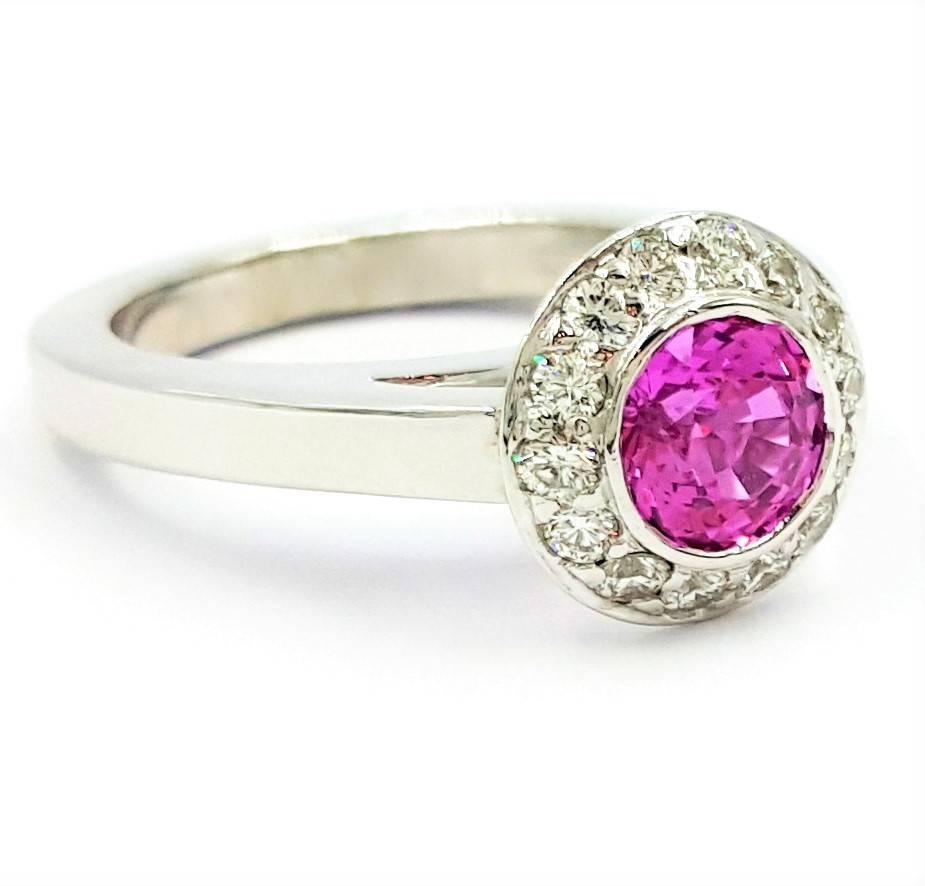 This ring is the definition of petite mixed with high fashion. Featuring as the center stone is a 1.25 carat Natural Intense Vivid Purplish Pink Sapphire cut in the old 16 facet european style giving off an abundance of light and igniting the