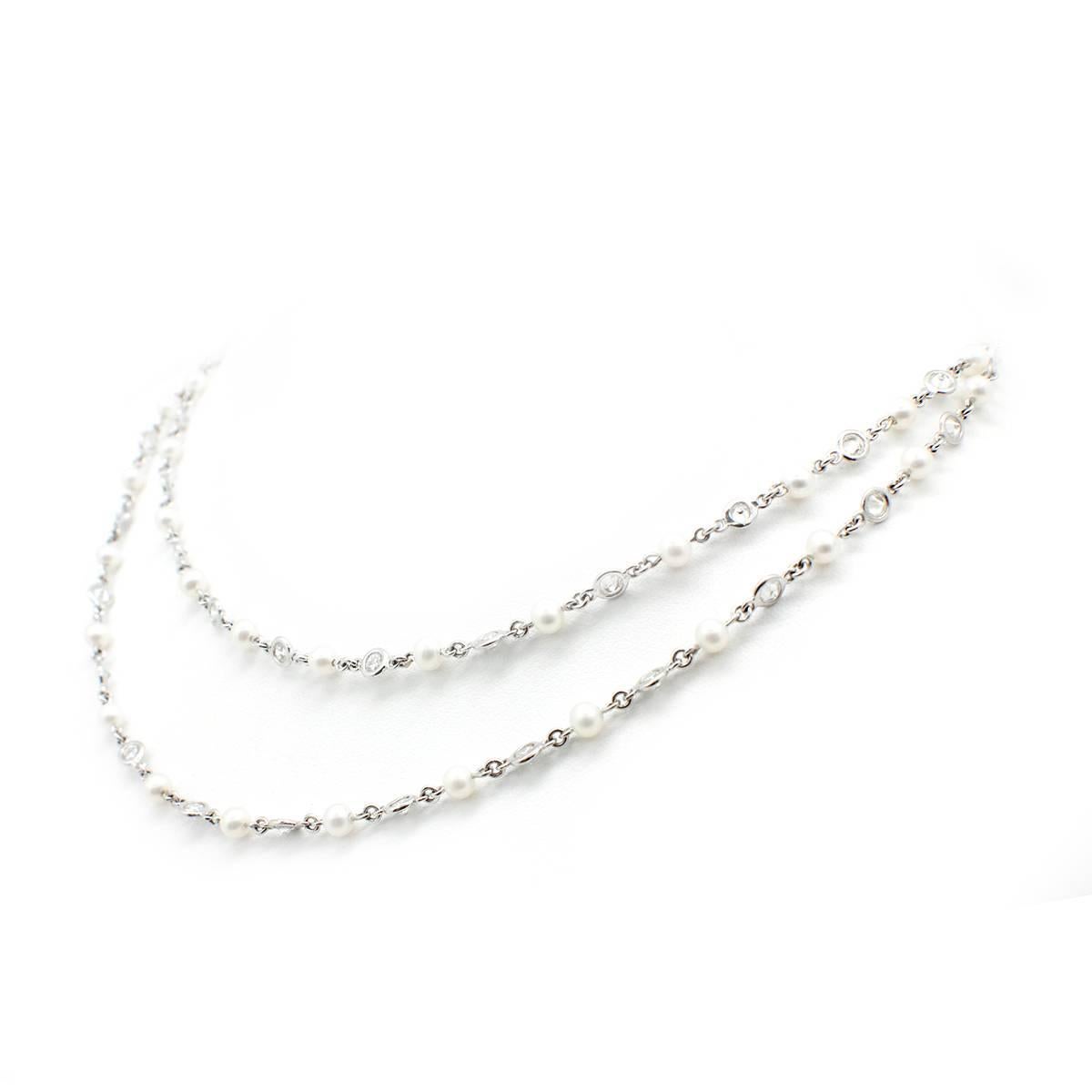This stunning chain is made in 18k white gold by designer Dena Kemp. The chain features white pearls alternating between bezel-set round brilliant diamonds. The diamonds have a total approximate weight of 3.50 carats, and they are graded G in color