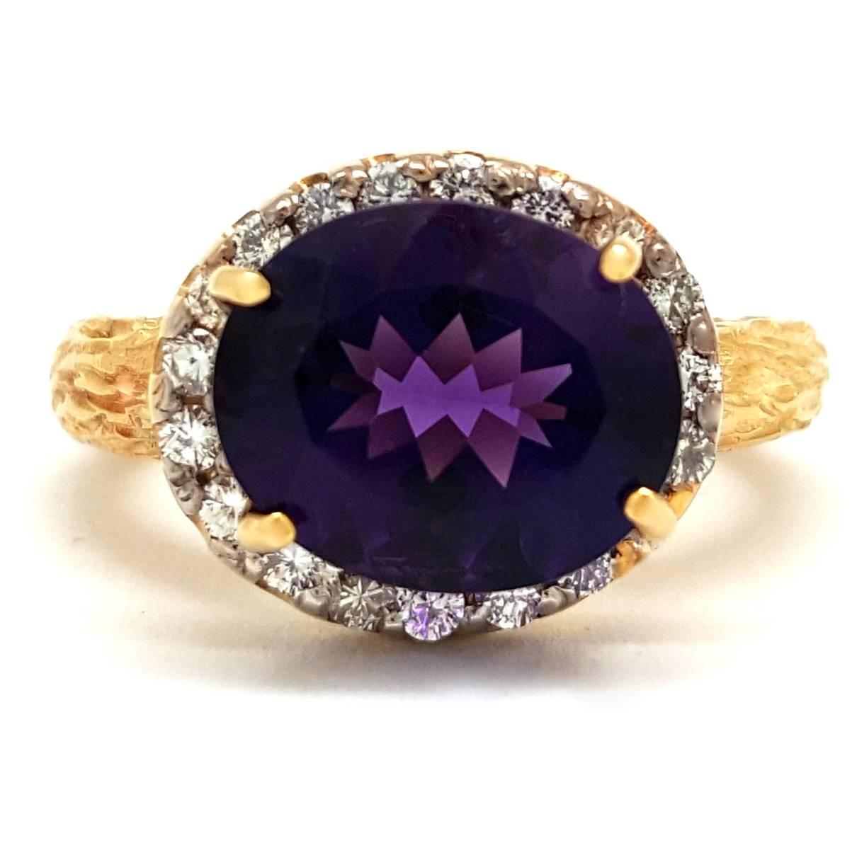 This one-of-a-kind ring features a faceted, oval-cut amethyst gemstone set at the center of a bark-carved 14k yellow gold ring. The shimmering Siberian amethyst weights 2.89 carats, and it is surrounded by a halo of round brilliant-cut diamonds for