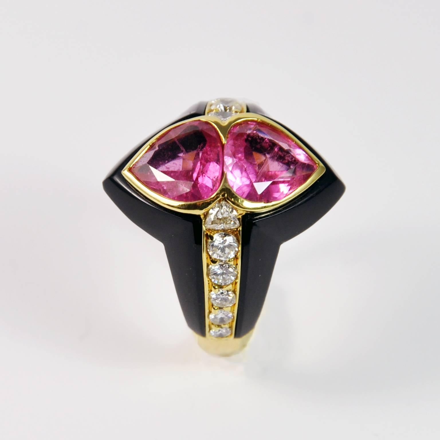 Carved and precisely adjusted Black Onyx highlight two lively pear shaped Pink Tourmalines and a line of diamonds . 
Details:  Ring Size: 6 ¾ (US), 54 (European). Resizing if possible is free of charge.