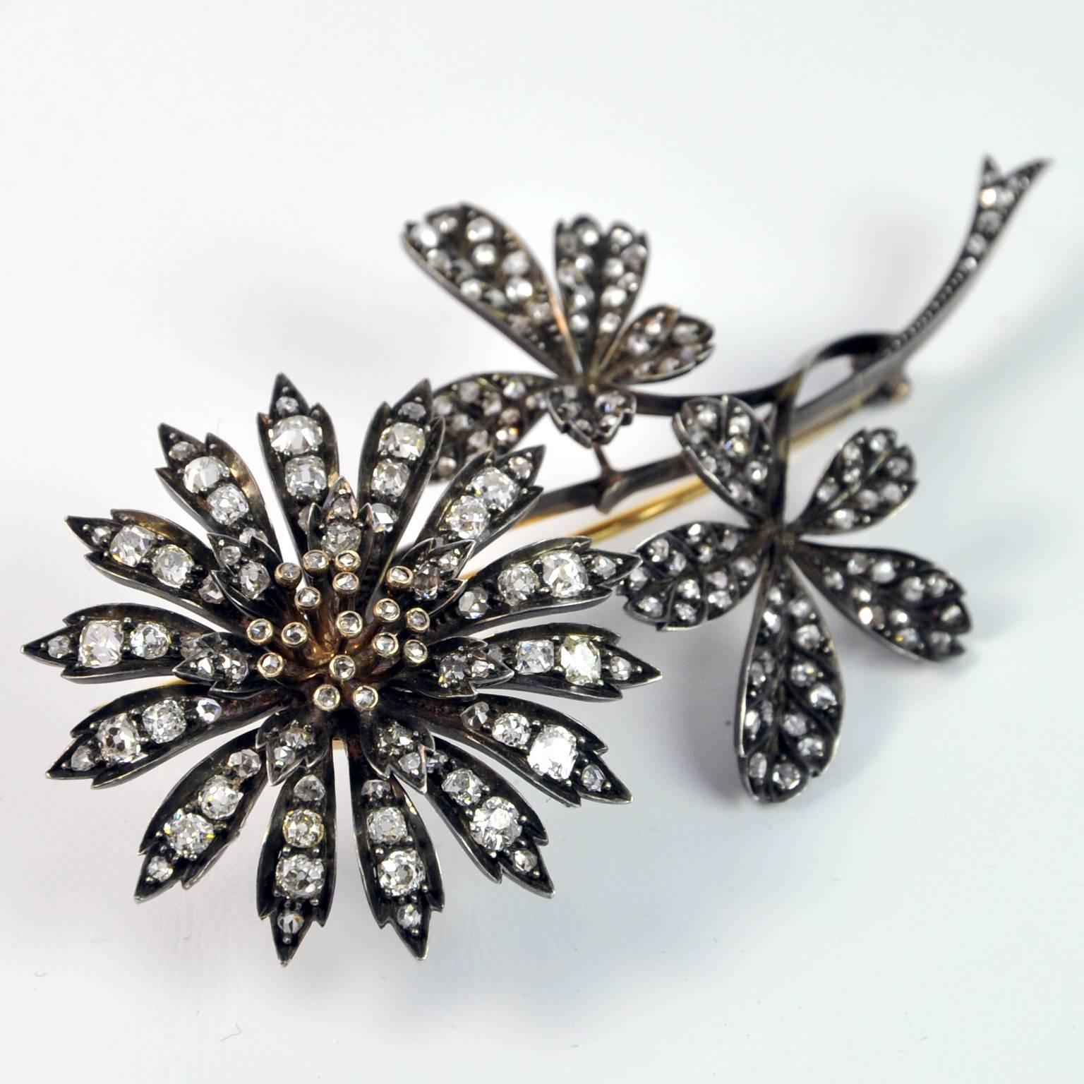 Victorian silver topped 18K gold floral design 'en tremblant' brooch set with old cushion and old rose cut diamonds.

French hallmarks, circa 1880.

Length 10 cm (4 in.) - Width ± 5.4 cm (2.1 in)
Diameter of the flower 4.5cm (1¾ in)