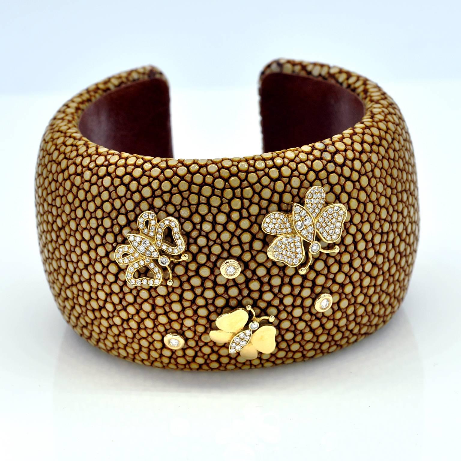 A trendy large shagreen cuff bracelet with yellow gold an diamond butterflies .