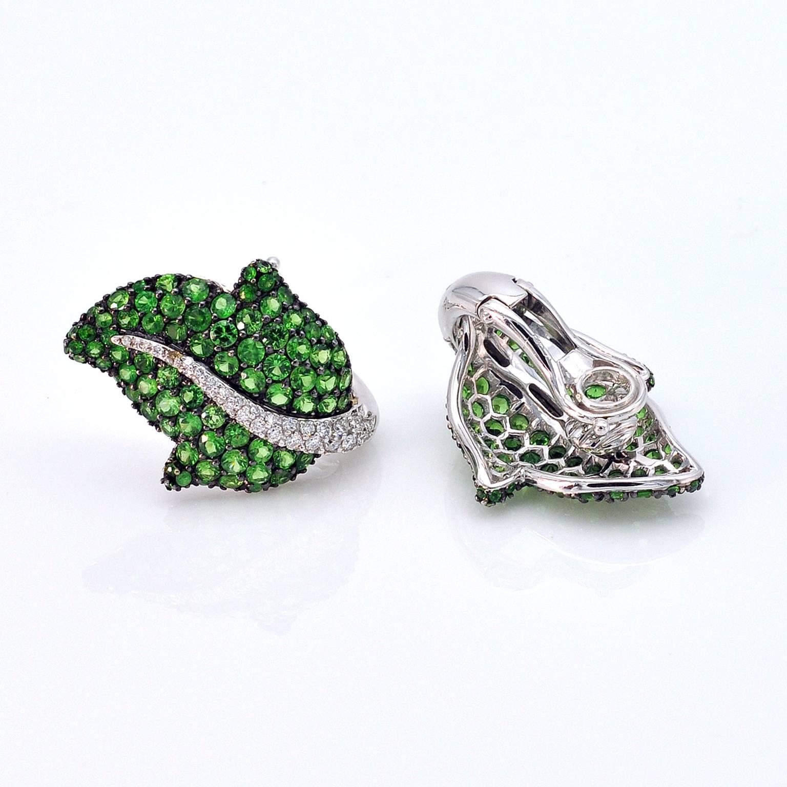 Elegant leaf shaped clip-on earrings. They have a foldable post so they can be worn both on pierced ears or not. They are set with 5.56 carats of brilliant cut vivid green tsavorites and 0.63 carat of white diamonds.
French Hallmark