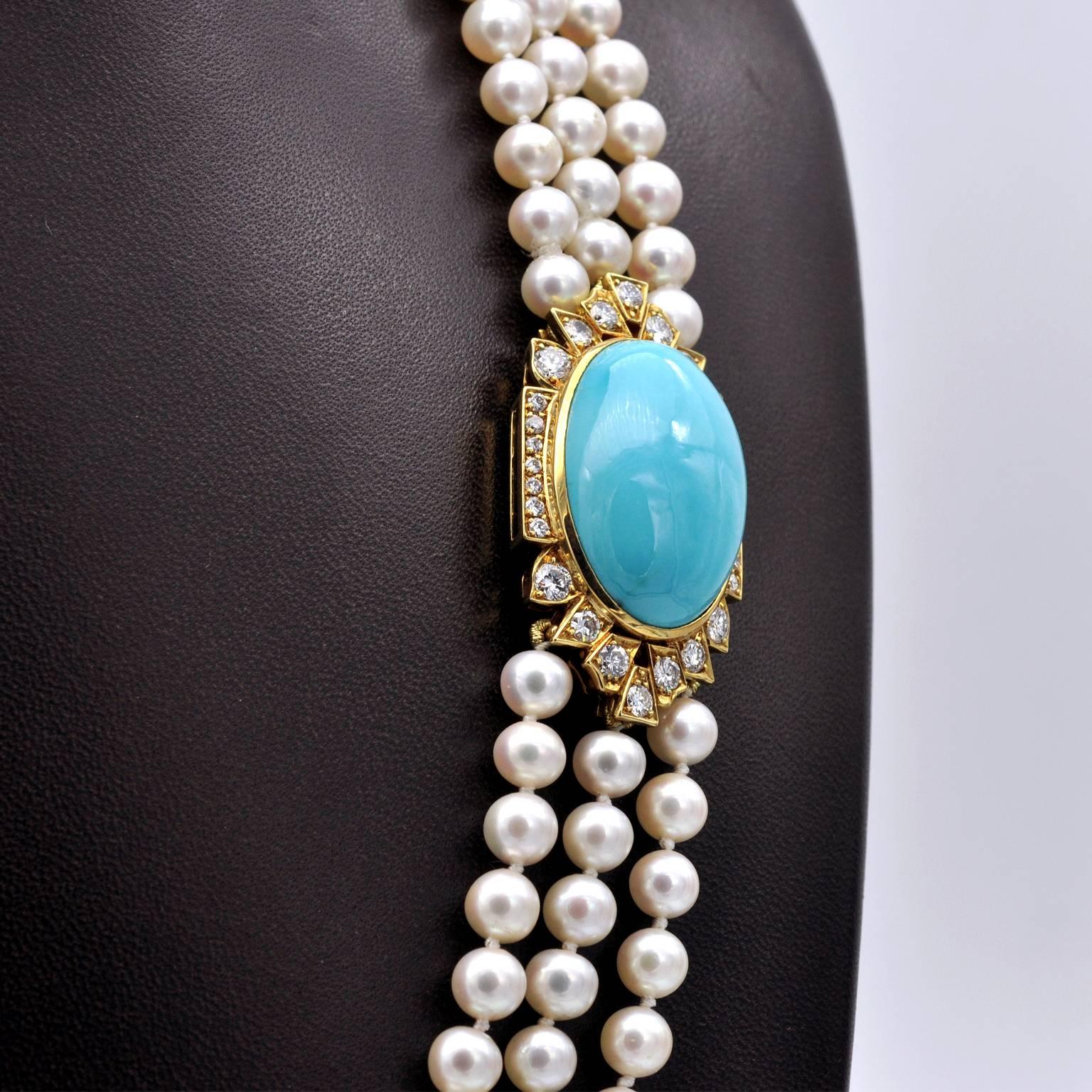Very elegant opera necklace: thee stands of white peals closing with a yellow gold clasp which is also the adornment of this piece. It consists of a 27mm long turquoise set in yellow gold and surrounded with approximately 2.2 carats of top quality