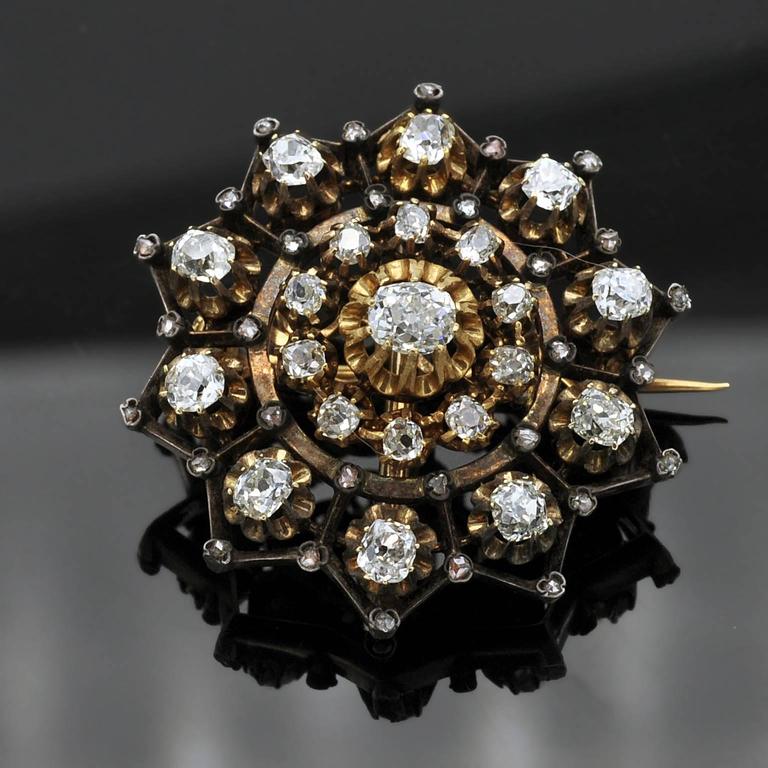 This ten pointed star Victorian round brooch is formed elegantly from 18 carat gold and silver. It is mounted with claw-set old mine-cut and highlighted with rose-cut diamonds. The diamonds are bright and lively. It has a detachable brooch fitting A