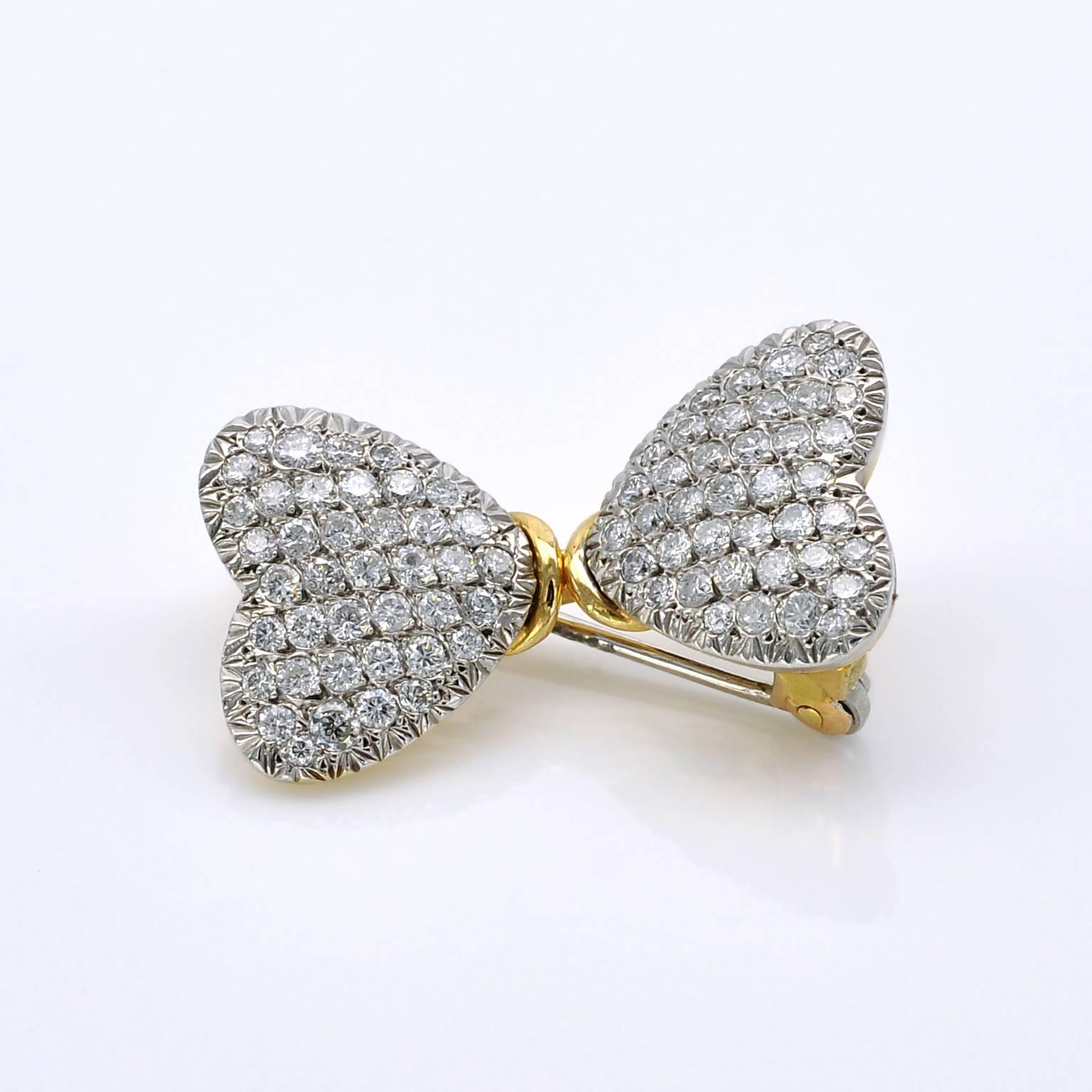 Two pave-set white gold hearts set with diamonds linked together by the point forming a butterfly shape. the back of the brooch is yellow gold.

Diamonds approximately:  1.5CT  color: G - clarity VS/SI 