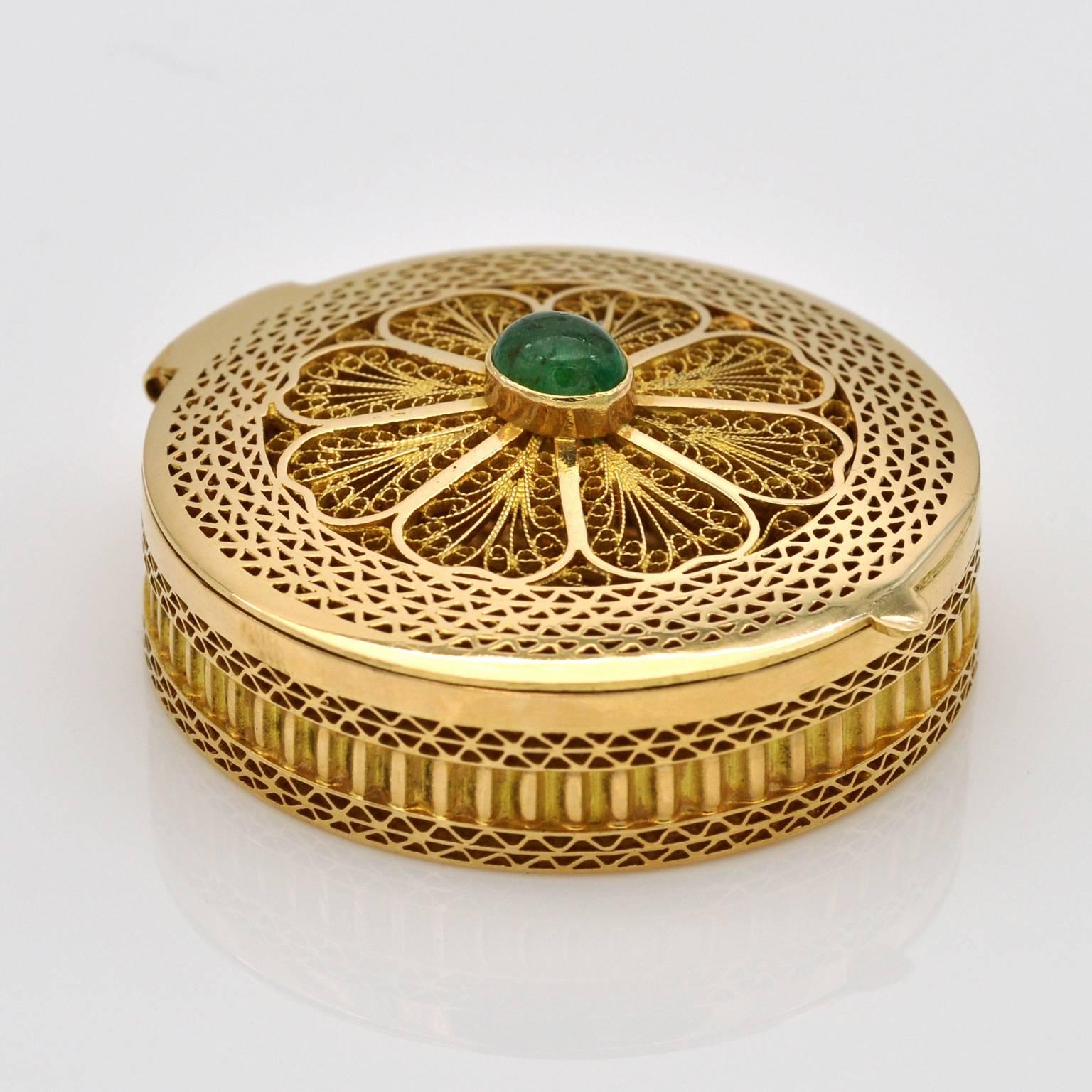 Very nicely crafted round pill box. Filigree 18KT yellow gold with an cabochon emerald  set on its top

Max height : 1.6 cm - 0.63in
Height Without  emerald: 1.25cm - 0.5in
diametre: 3.8cm - 1.5in
