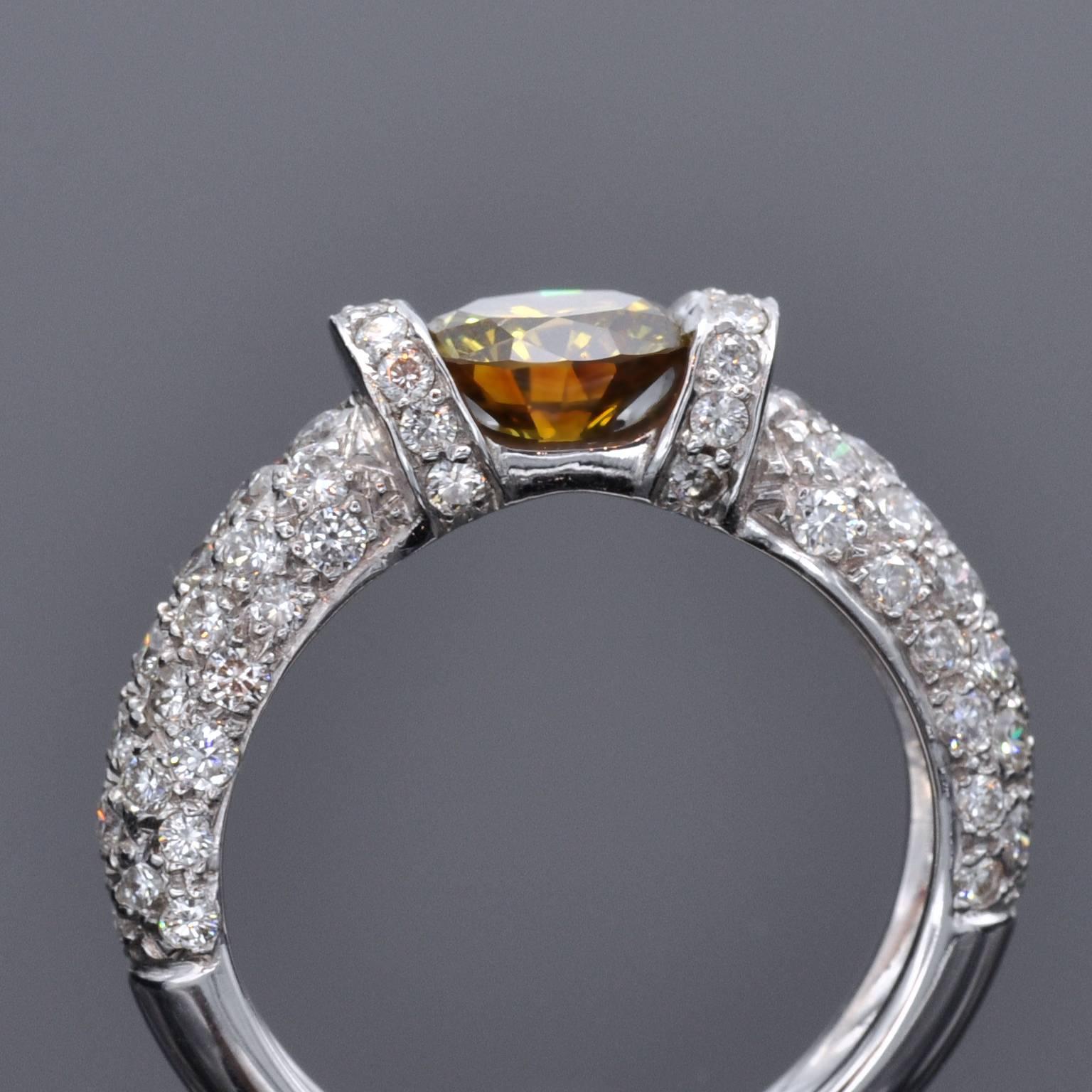 Erstaunlicher Verlobungsring mit Solitär. Der zentrale Diamant, ein 1,25 Karat intensiver orange-gelber runder Brillant, wird nur an den Seiten gehalten und enthüllt seine Schönheit von allen Seiten. Es wird mit einem HRD-Zertifikat (dem führenden