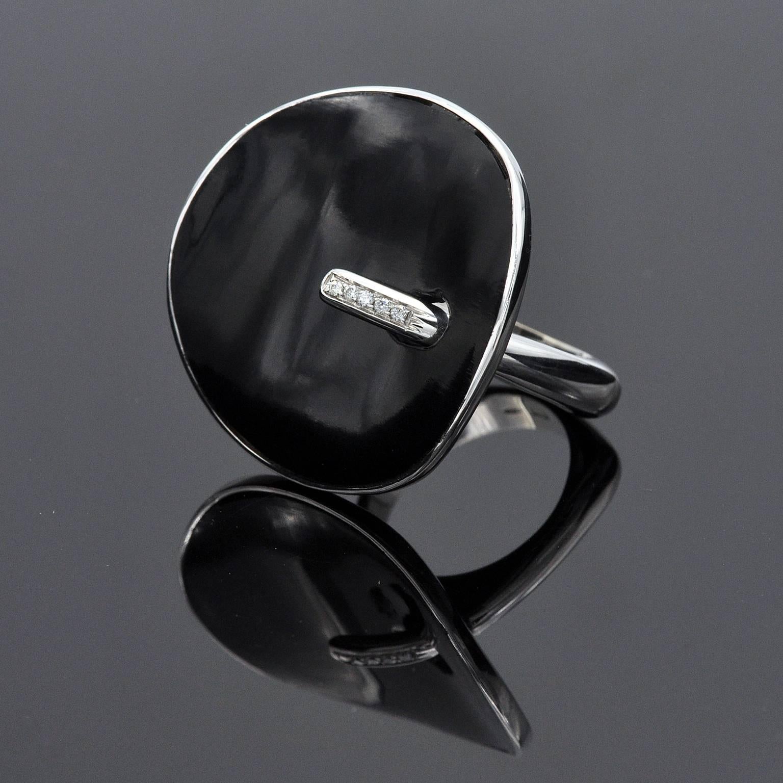 Modern cocktail Ring with a strong contemporary design. A large onyx curved disc on 18 kt white Gold highlighted with white diamonds.