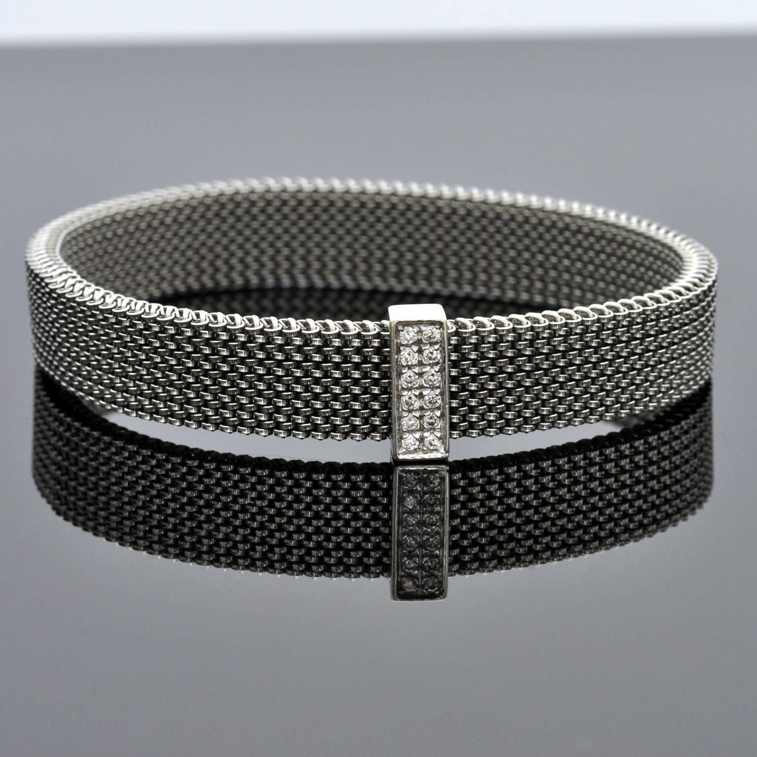  White diamonds on 18 Kt white-gold on a steel spring like band. 
Stylish and elegant bracelet for every day use.