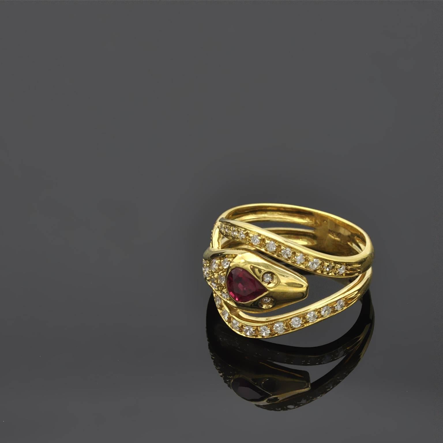 A 18kt yellow gold snake ring wrapping around the finger ring. A pear shaped ruby on its head the eyes and body are set with diamonds.