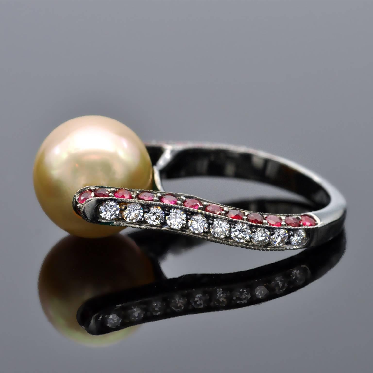 Unique modernist ring. It is a lyra shaped ring in blackened 18 KT gold holding a Golden south-sea pearl. On the shaft round rubies and diamonds are set.
Deatails
South sea Pearl 11.5-12 mm
Rubies: 1.70 carat
Diamonds: 0.51 carat