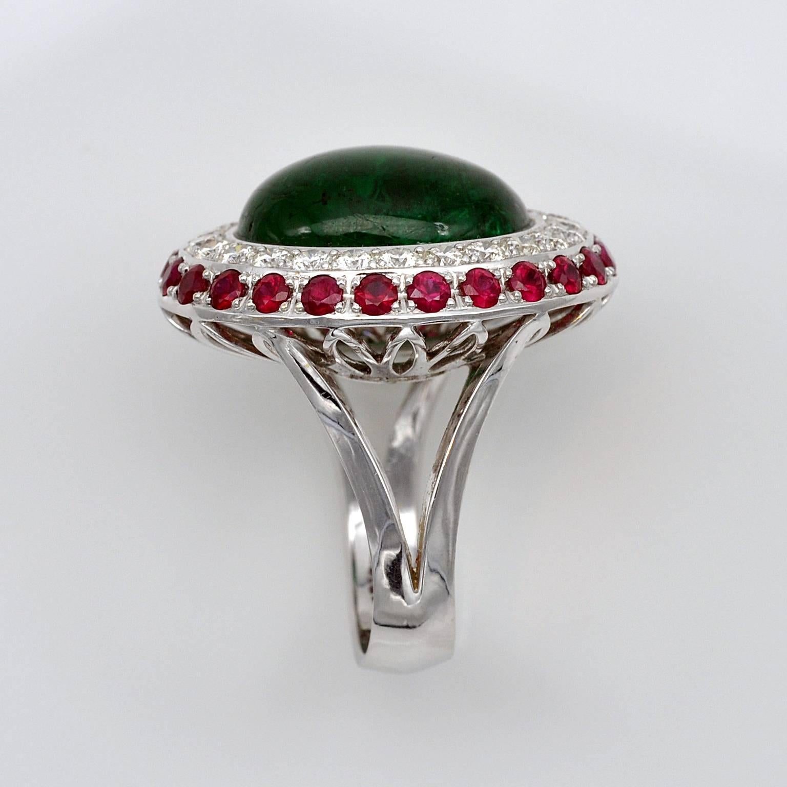 Impressive halo cocktail ring. A 16.09 carats Emerald cabochon is surrounded by a row of brilliant cut diamonds and rubies.
The emerald comes with a G.I.I. certificate.
