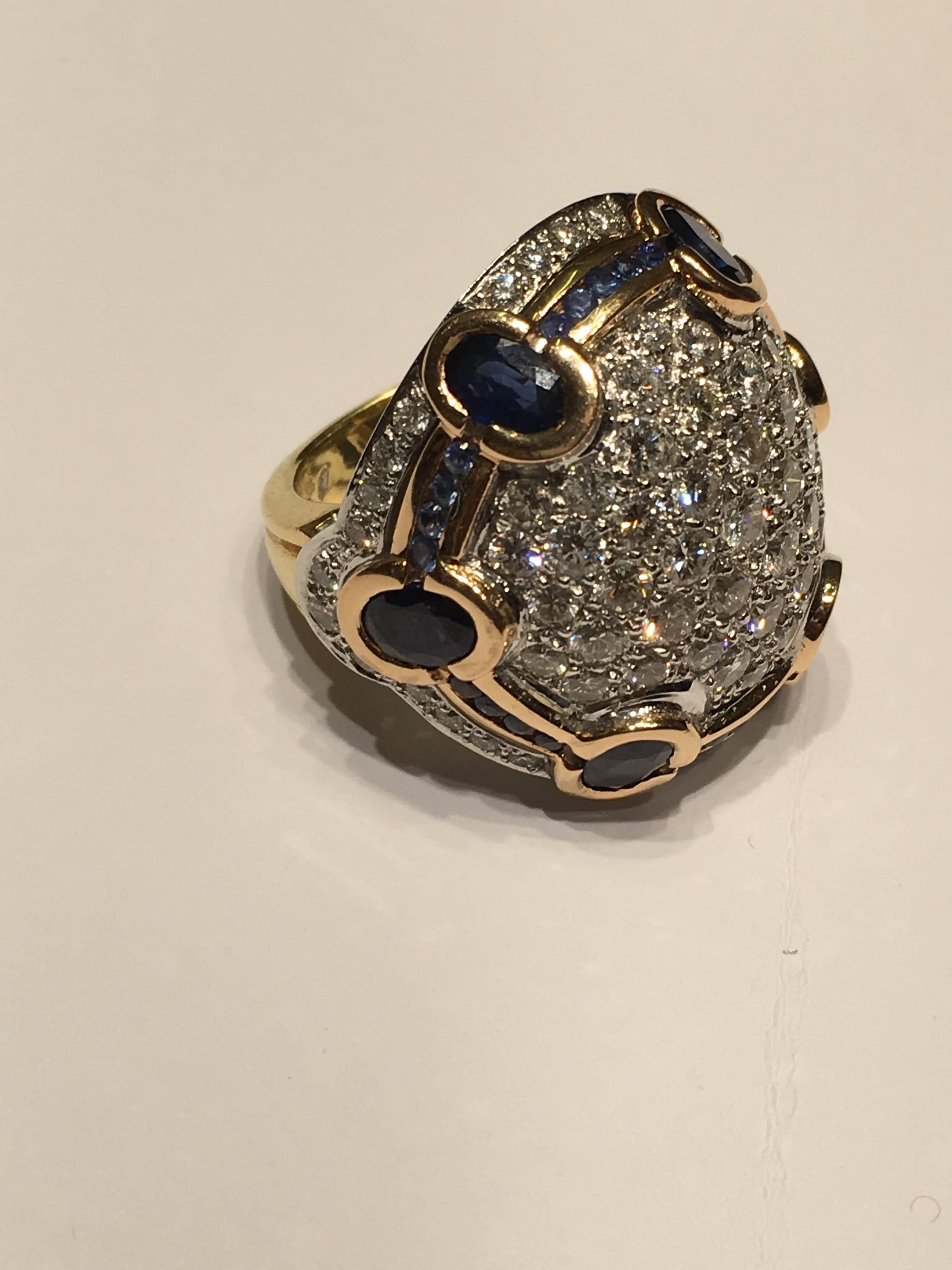 This beautiful Bombay Pave Ring is set with diamonds and sapphires in 18ct
Yellow and White Gold. With Oval and Round Sapphires
Approx 6CTS of Sapphires and 5CTS Plus of Diamonds of high Colour
SIZE UK (O)  SIZE US ( 7!/2)
Can be sized free of