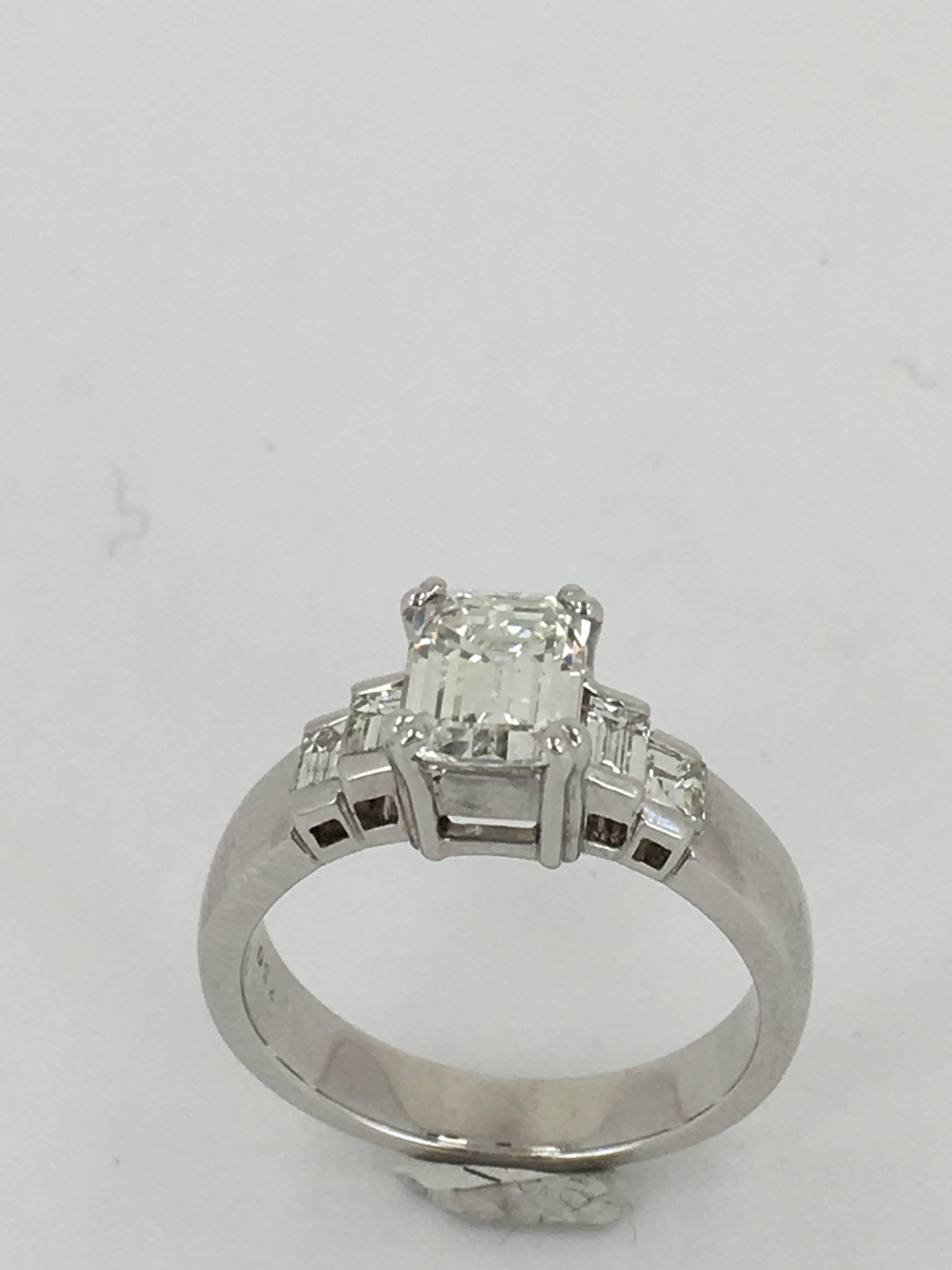 Emerald Cut Diamond Solitare Center Stone 1.21CTS Colour H VS2
Flanked with four bagettes total weight in excess of .50ct. Set on 18ct white Gold.

Size UK (M)    SIZE US (6)

Ring size can be adjusted at no cost