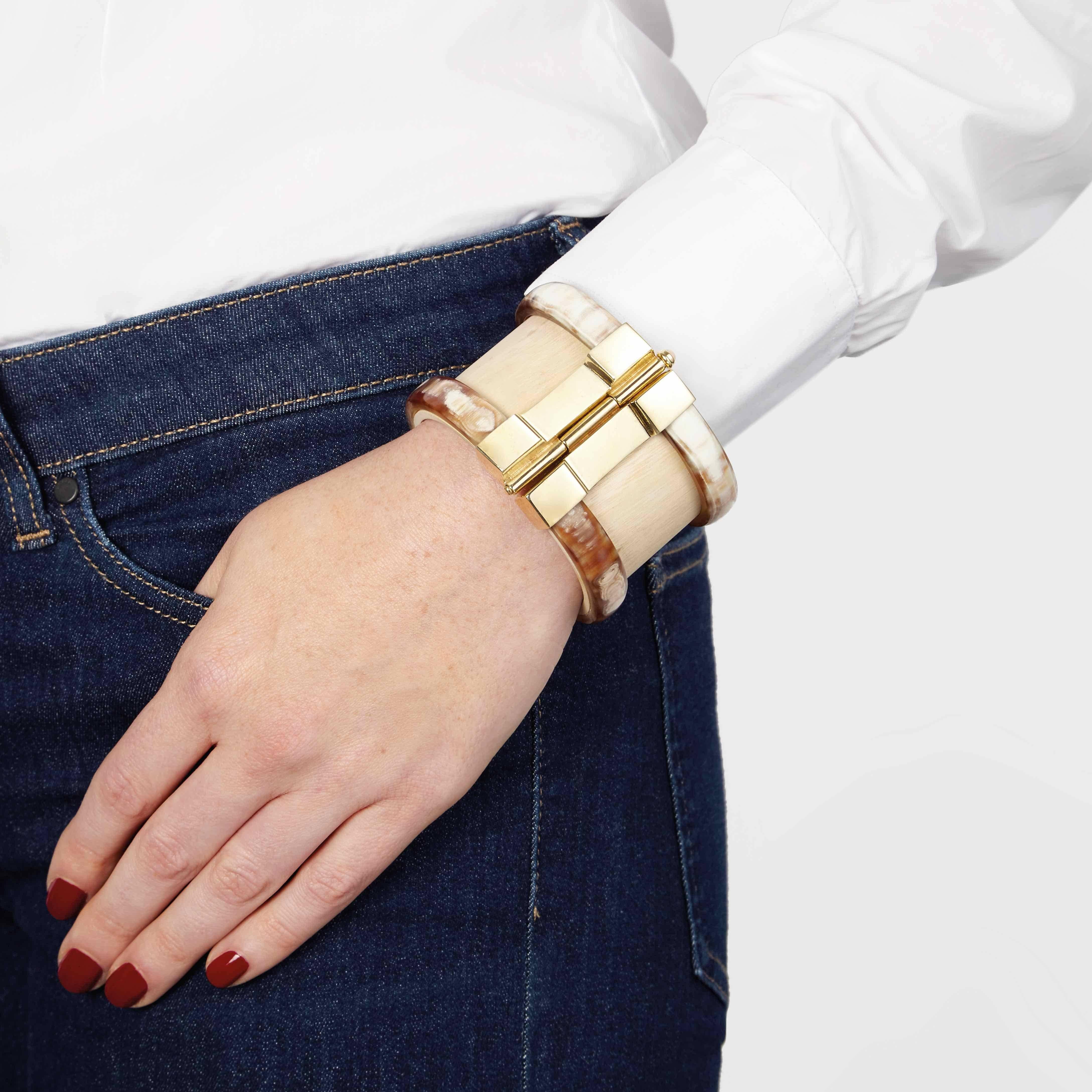 Cuff bracelet crafted by hand from jacaranda wood and African cow horn. The customizable 18k gold plate pin-clasp is set with a choice of emerald, ruby or fire-opal cabochon. 

Hand crafted by artisans in Kenya, East Africa and finished by hand to