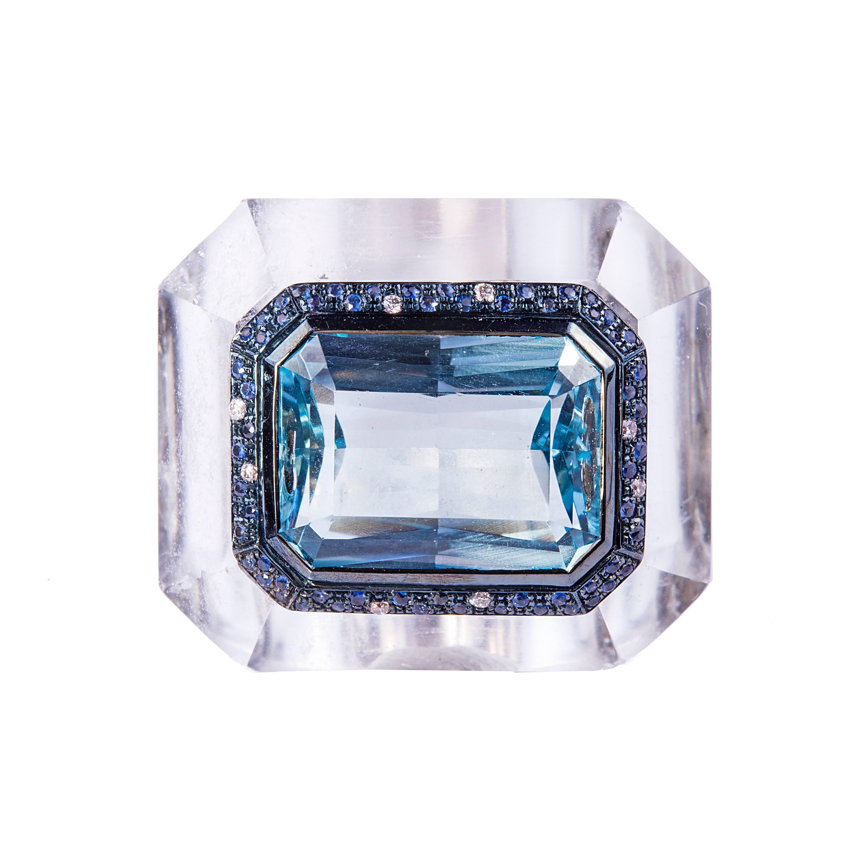Nuur Collection - A 18kt gold and rock crystal ring featuring an aquamarine of 12 carat circa surrounded by 1.00 ct circa of sapphires and diamonds. The rock crystal was cut and carved by hand.