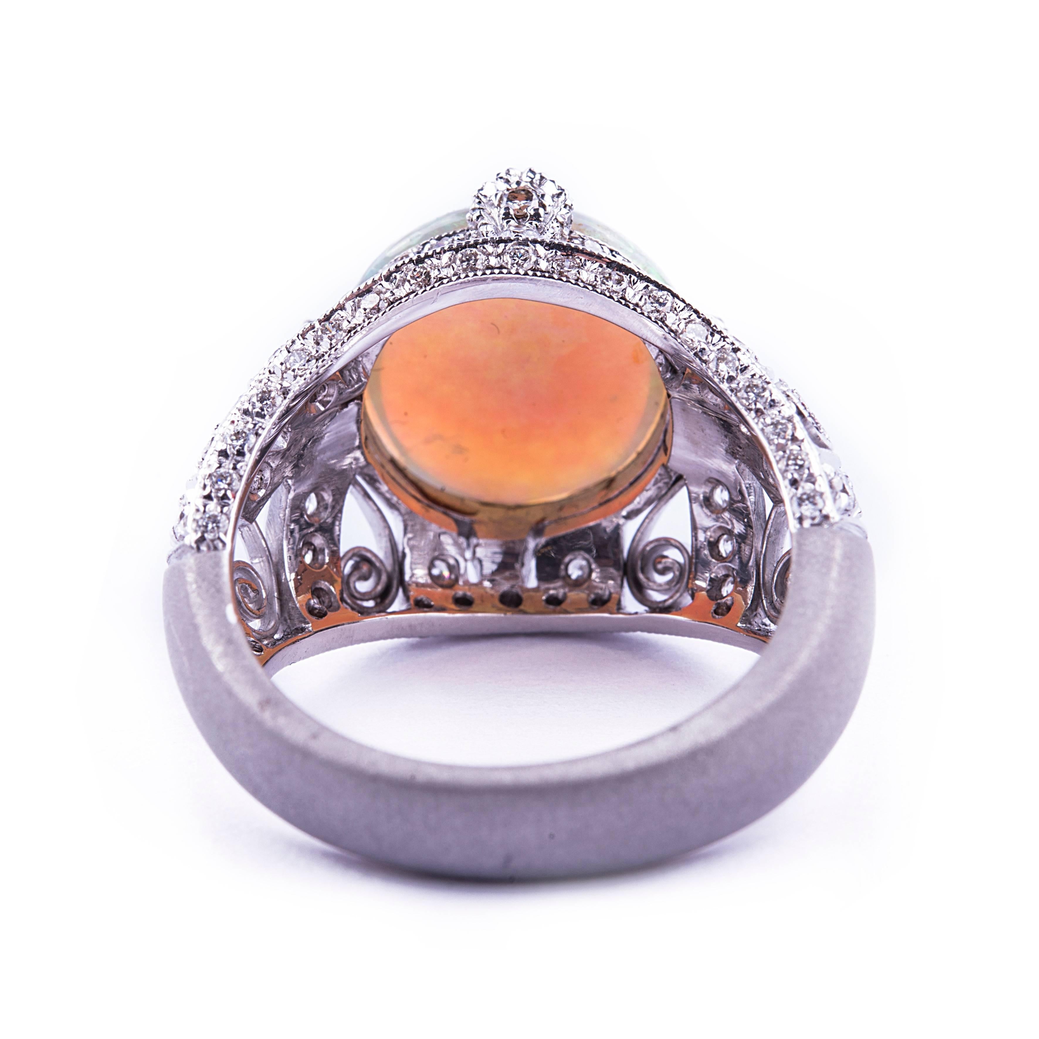 An Art Deco inspired 18kt gold mounting set with 84 diamonds weighing 1.02 ct  and centered with a beautiful opal.