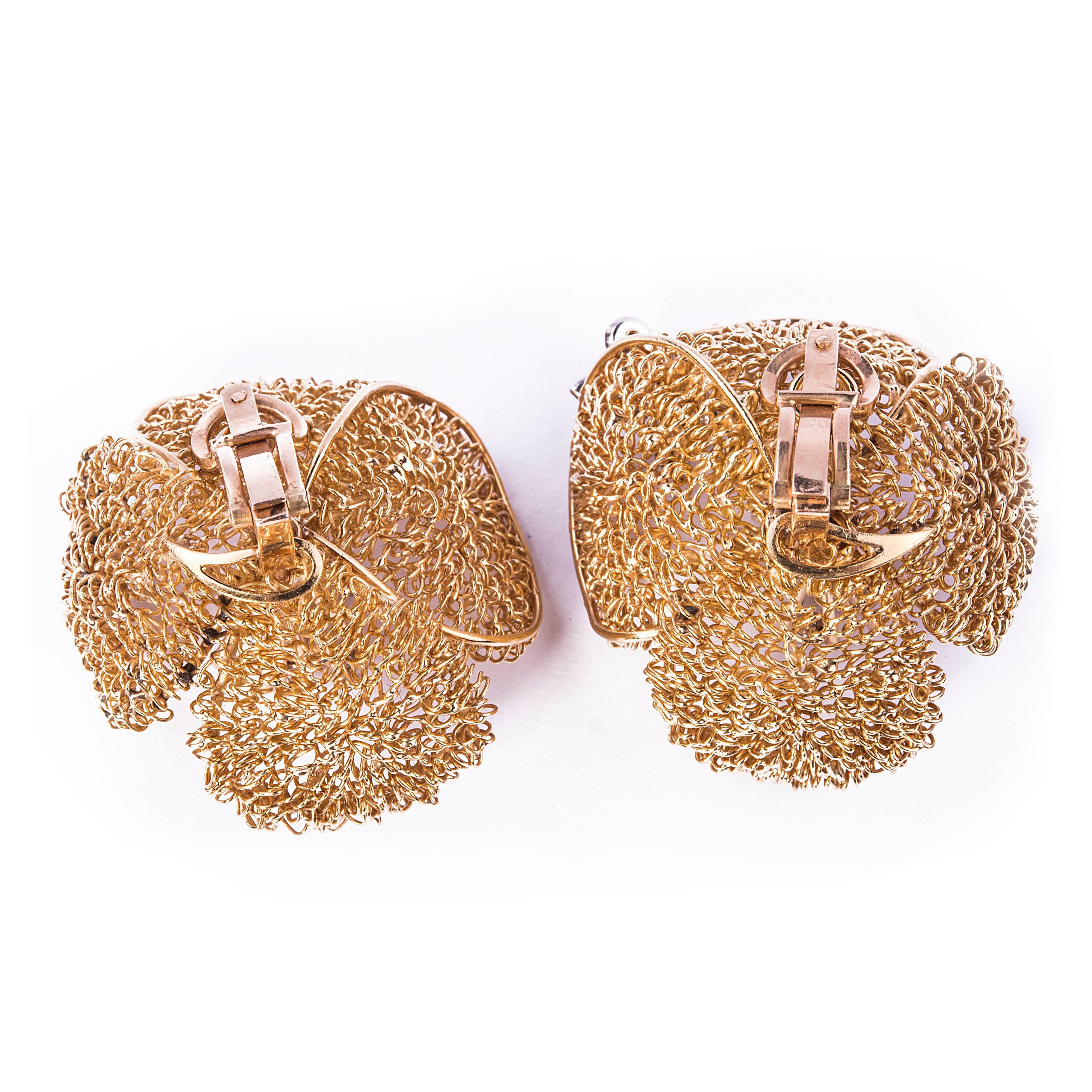 A pair of 18 kt gold vintage flower earrings. Each earring is centered by six diamonds. On one earring there a diamond butterfly is attached.