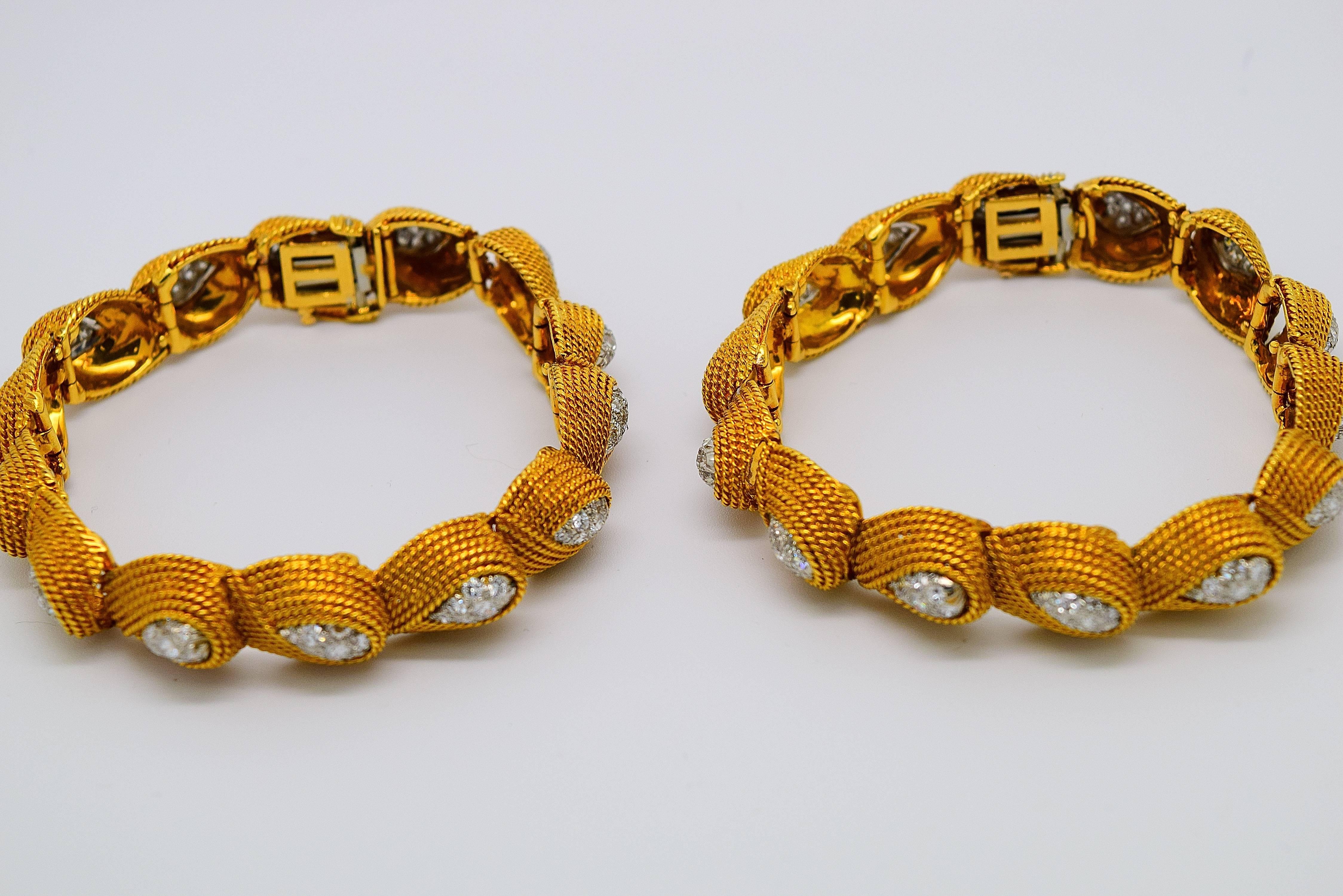 A matched pair of David Webb 18k yellow gold, platinum and diamond bracelets. The round brilliant cut diamonds are set in platinum micropave style surrounded by 18k cord textured gold. The diamonds weigh approximately 6.50cttw of fine diamonds