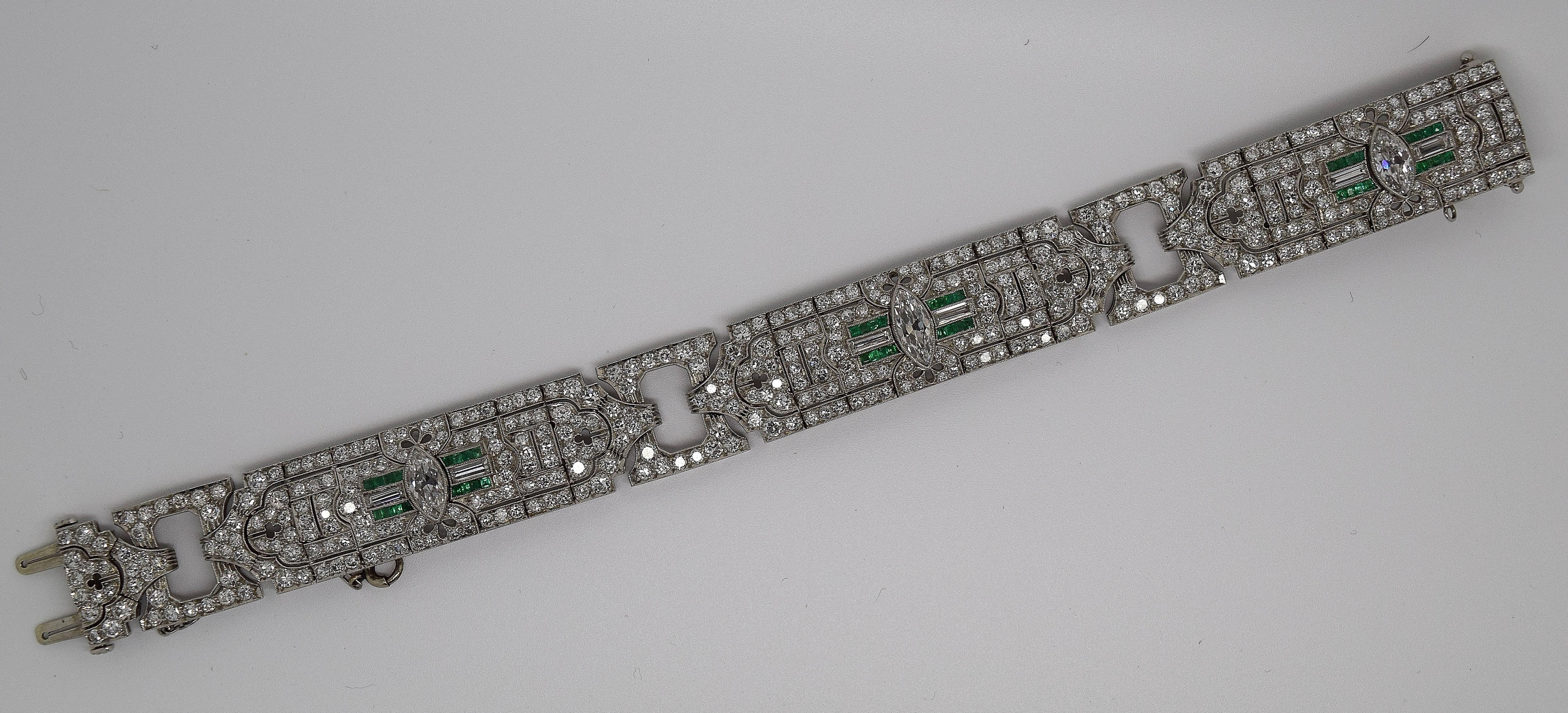 Stunning Art Deco diamond and emerald bracelet set in platinum. The three center marquise cut diamonds weigh approximately 3.75cttw and are approximately G/H color and VS2 clarity. The 432 side old cut diamonds are hand set in platinum filigree and