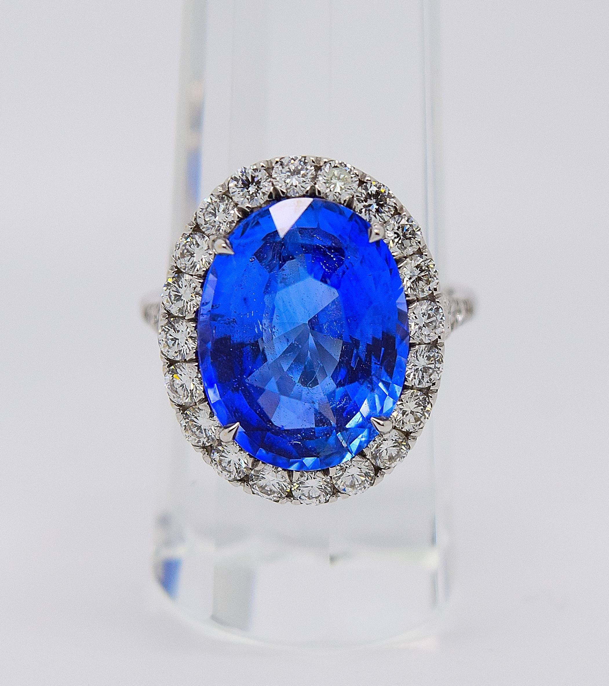 Impressive natural oval blue sapphire and diamond cocktail ring set in 18k white gold. The Princess Diana style ring is centered by an oval blue sapphire that is 10.49 carats and has a GIA report #2161212022 stating that it is natural sapphire. The