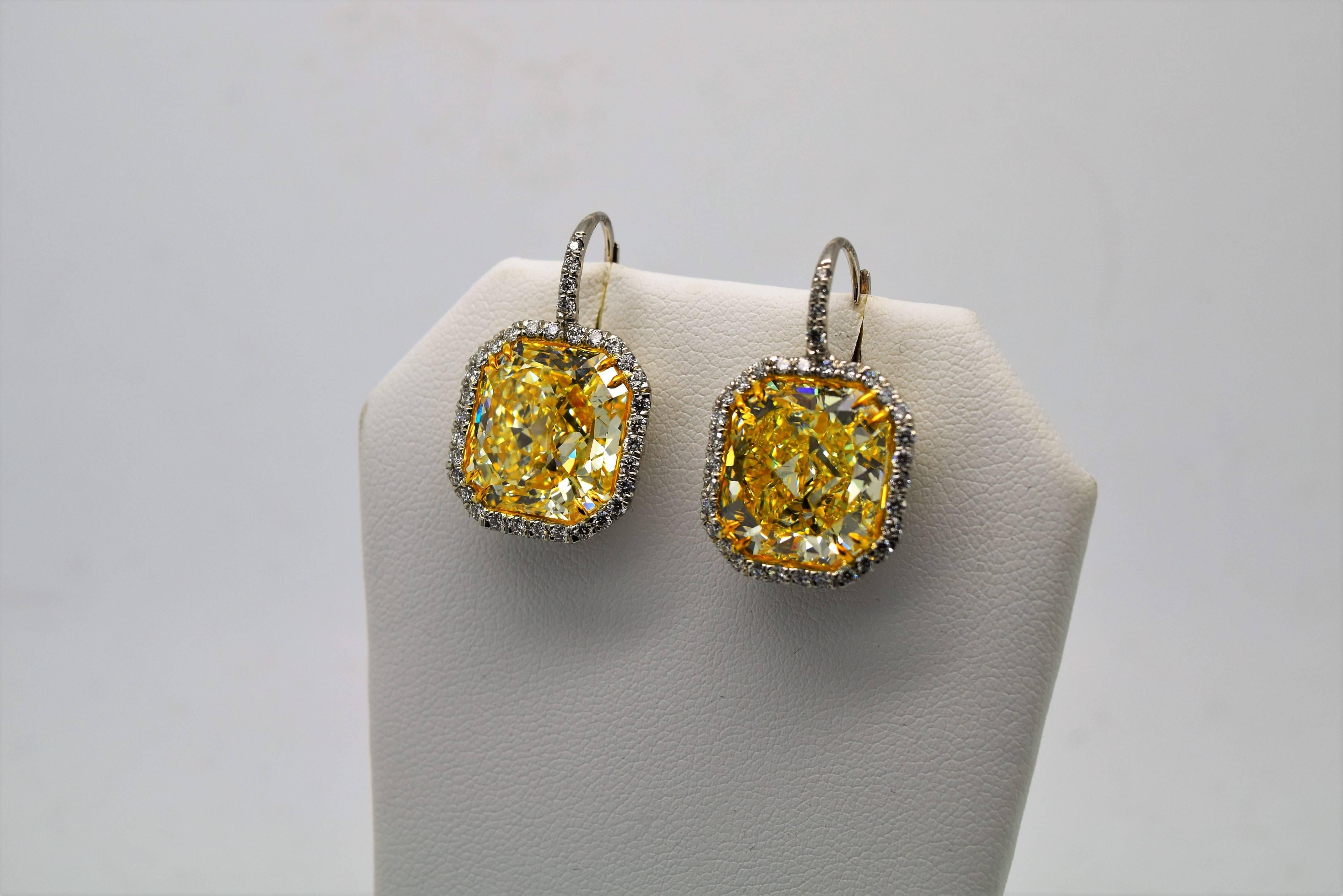 This is a very rare and important pair of 24.33 carat total weight Fancy Yellow Radiant cut diamond earrings set in platinum and white gold.

The earrings consist of two 12 carat Fancy Yellow Radiant cut diamonds:
1) 12.31ct Fancy Yellow VS1