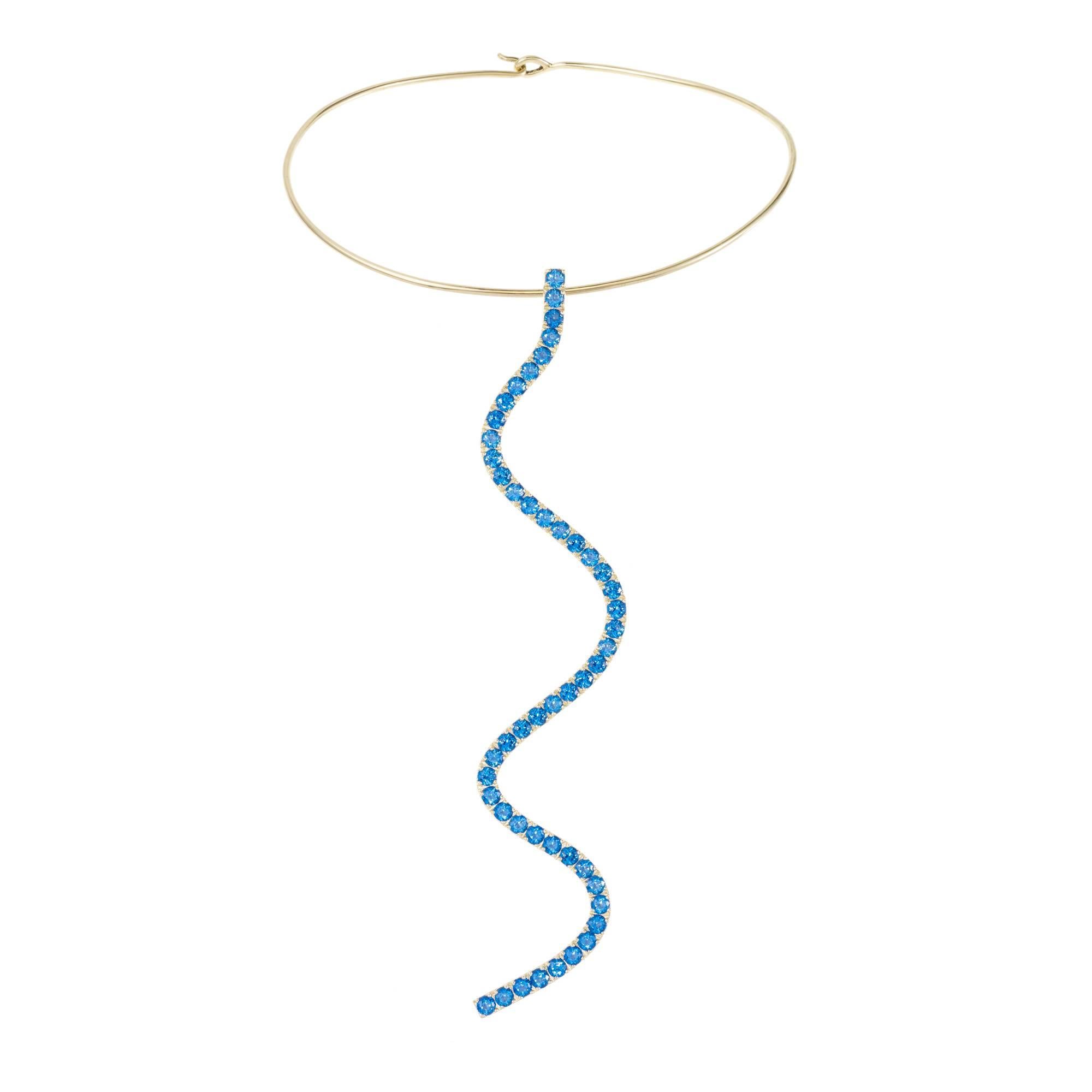 *MADE TO ORDER - 5 WEEK LEAD TIME*

Sabine Getty wiggly torque with wiggly pendant in 18k yellow gold set with blue topaz.
Topaz: 14.21ct

Yellow, pink, green and blue. Four colours inspired by the Memphis Group, the kookiest of Made in Italy