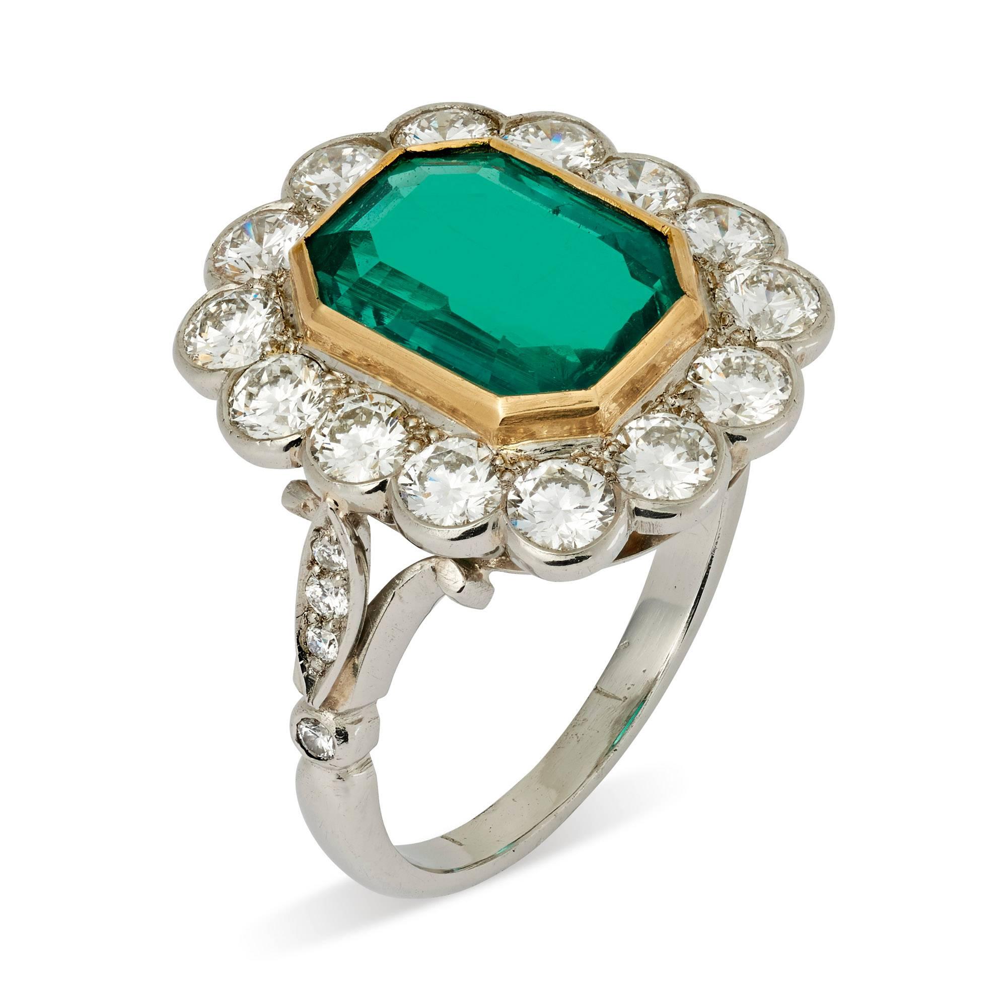 A superb emerald cut Colombian emerald and diamond cluster ring beautifully mounted in 18ct yellow gold and platinum

Emerald 3.379 carats
Measures 11.17 x 8.34 x 4.59mm
SSEF Certificate No. 84946 dated 29th March 2016

Total weight of diamonds 1.86