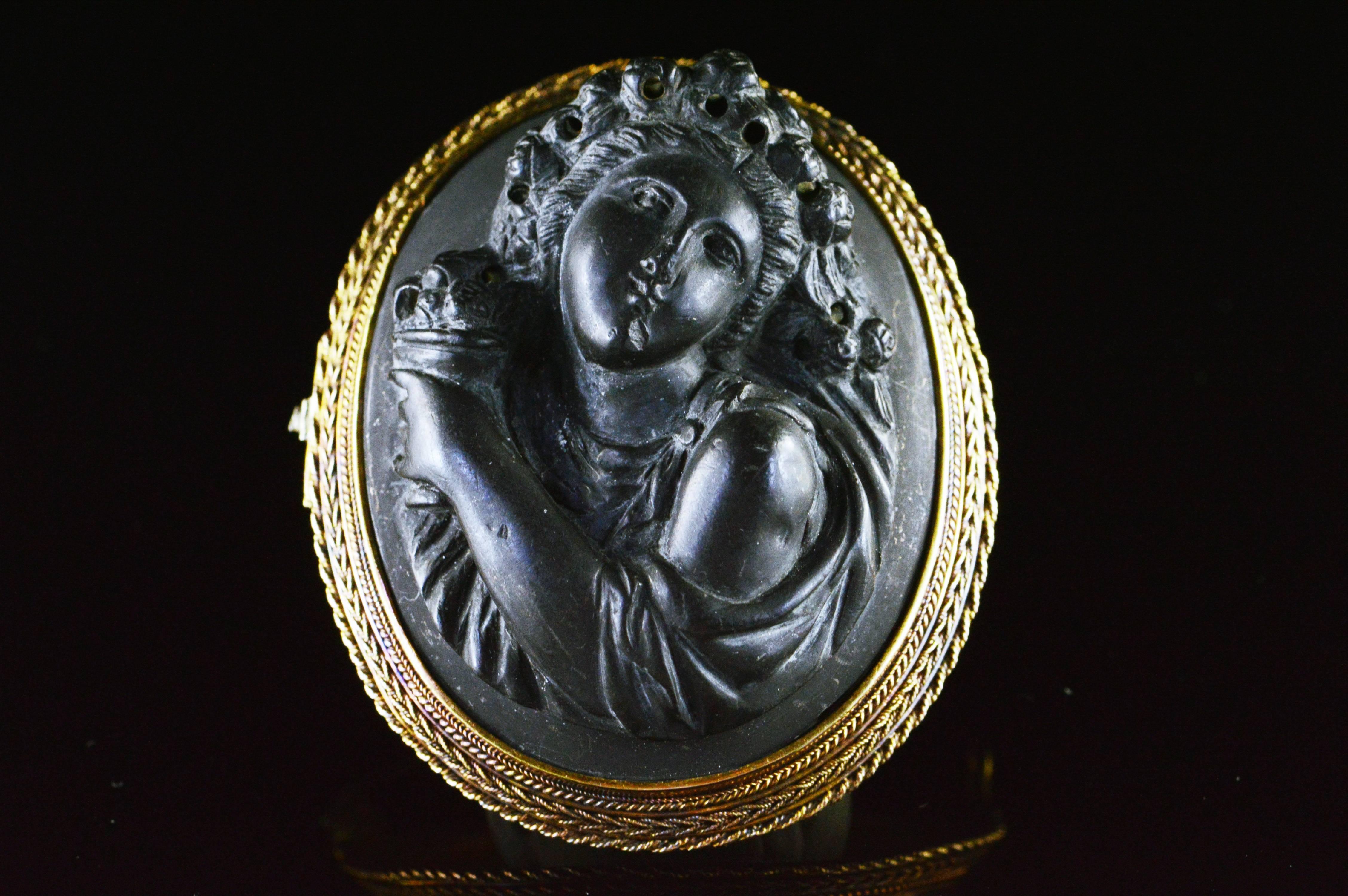 This is a hand carved beautifully detailed female figure cameo. This brooch is carved in high relief into black lava stone with incredible detail. This item is believed to date from the 1860's or 1870's and is an exquisite statement piece.

All