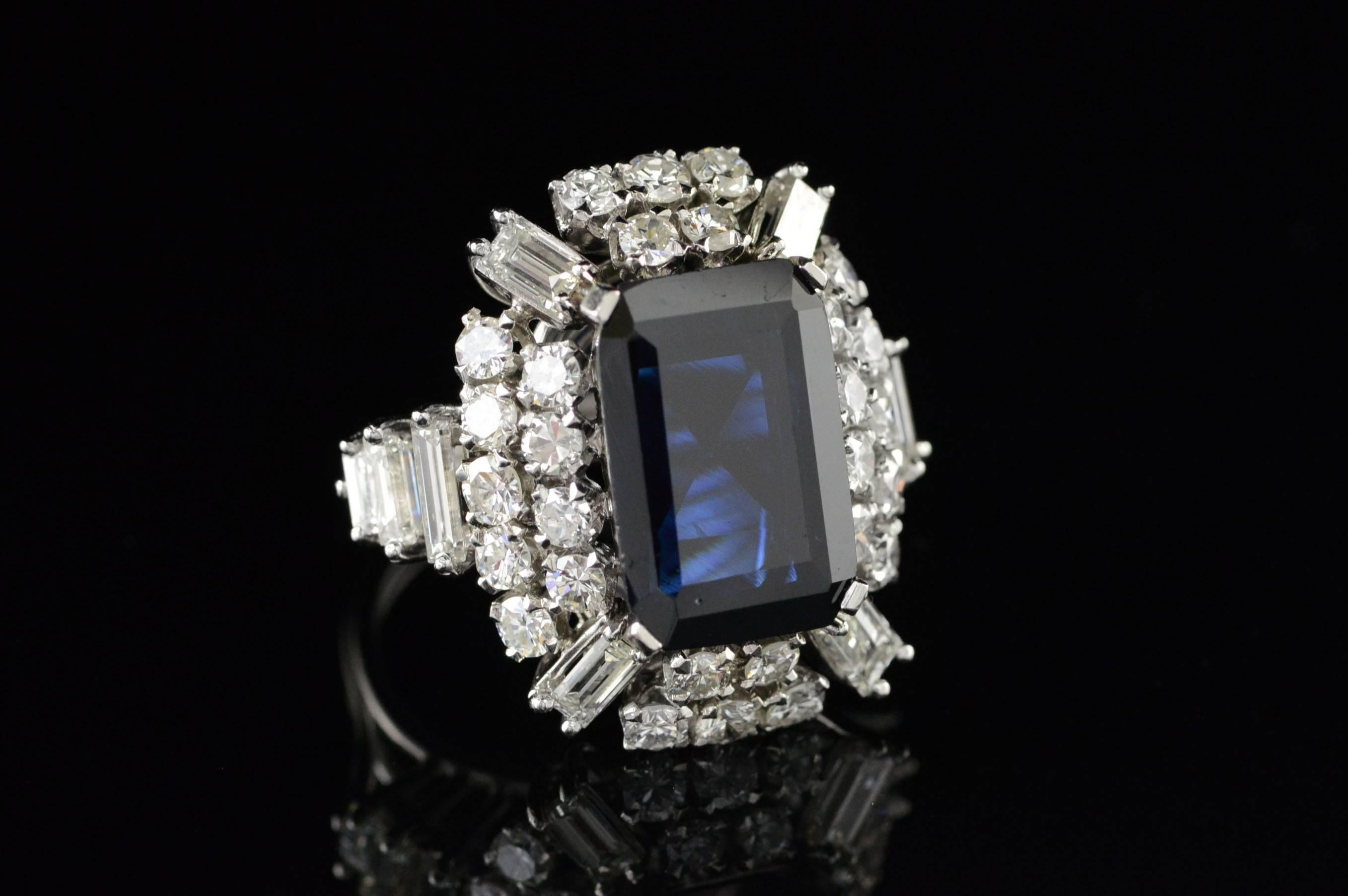 This incredible statement ring demands attention with its impressive size and classical Art Deco stylings. The center stone is a massive Sapphire of over 8 carats flanked by over 4 carats of round brilliant and baguette diamonds.
Fit for a red