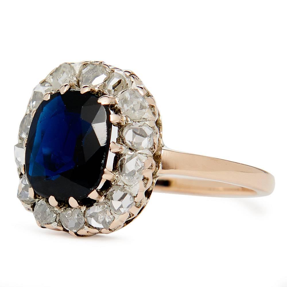 Beacon Hill Jewelers Presents:

A beautiful original georgian period sapphire and rose cut diamond engagement ring in 14 karat rose gold. Centered by a beautiful rich vivid blue cushion shaped sapphire, this ring features a halo of rose cut