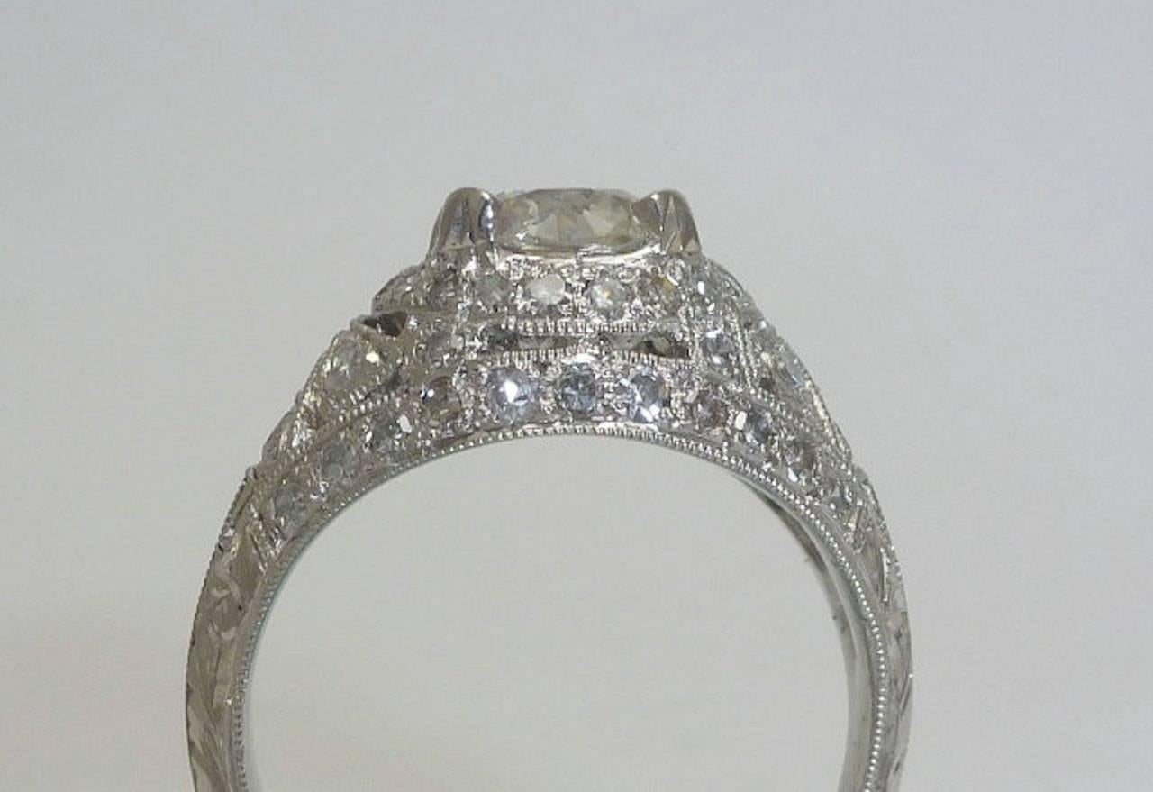 Beacon Hill Jewelers Presents:

A stunning edwardian platinum and diamond engagement ring set with fifty one sparkling diamonds. Centered by a large european cut diamond, this fantastic ring features beautiful hand engraving and mille graining work