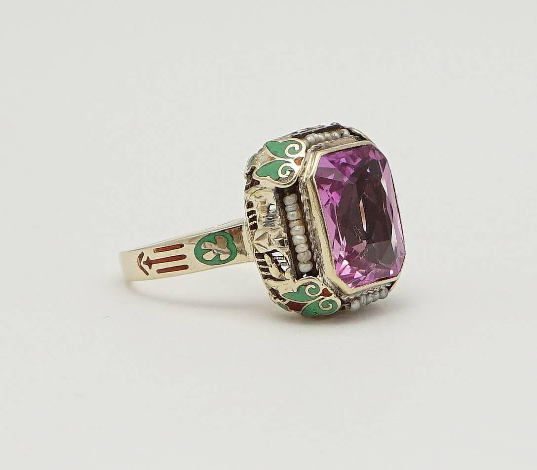 Beacon Hill Jewelers Presents:

A beautiful art deco period pink spinel, seed pearl, and enamel filigree ring in 14 karat yellow gold. Centered by a sparkling emerald cut bezel set pink spinel this ring features beautiful floral filigree and