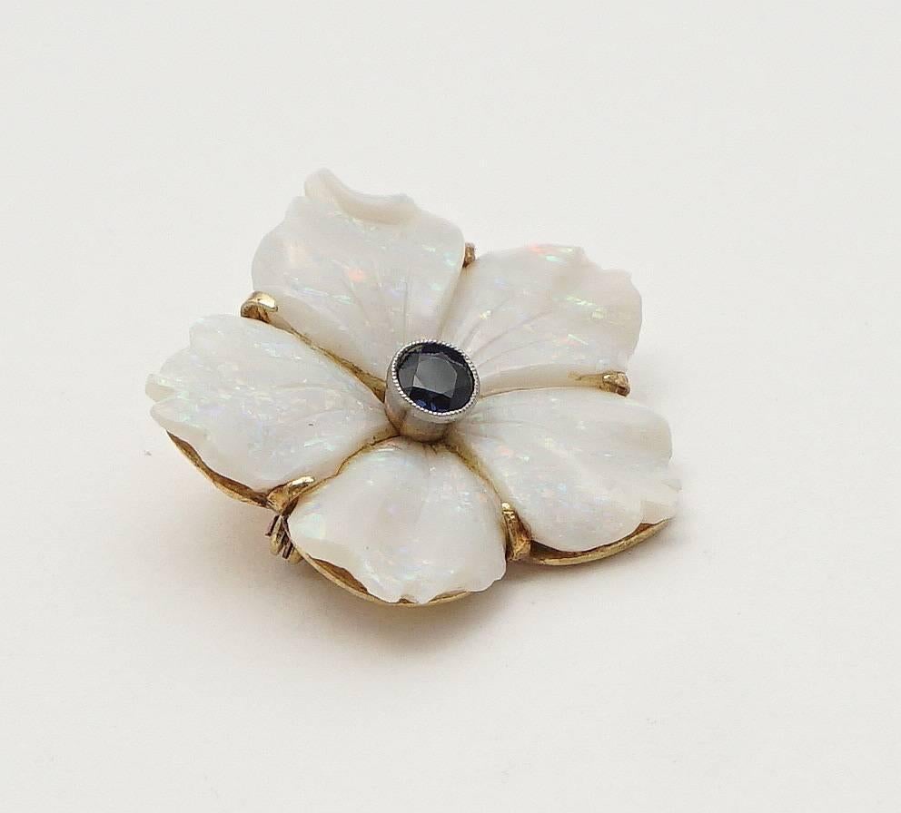 Beacon Hill Jewelers Presents:

An edwardian period carved opal flower pendant in 15ct yellow gold and platinum. Featuring five beautiful carved opal petals, this pendant is centered by a beautiful vivid blue sapphire set in a platinum