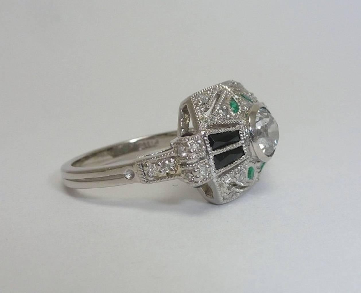 Beacon Hill Jewelers Presents:

An art deco style diamond, onyx, and emerald ring in platinum. This beautiful ring features a center european cut 0.60 carat diamond surrounded by French cut Onyx baguettes, marquise cut emeralds, and sparkling