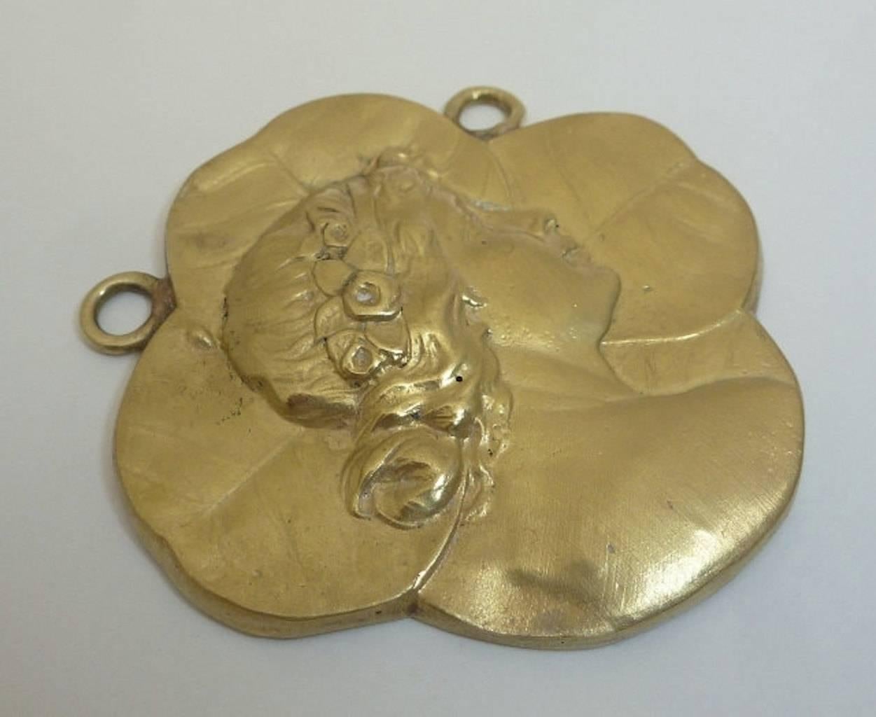 Beacon Hill Jewelers Presents:

An art nouveau Figural pendant in luxurious 18 karat yellow gold by the famed Marcus & Company. Weighing a substantial 26 grams and measuring nearly 2 inches in diameter, this pendant is a true rarity due to