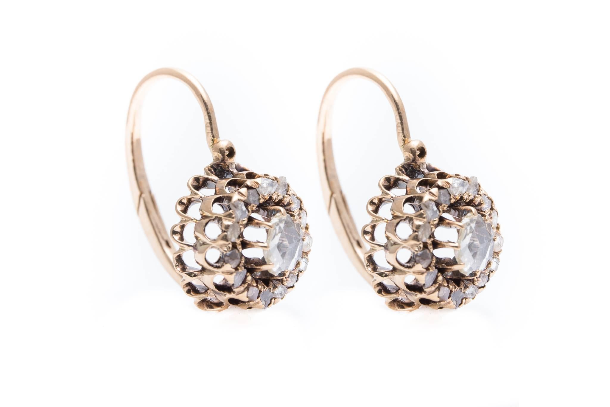 A superb pair of antique Georgian period diamond earrings in yellow gold. Featuring a center rose cut diamond surrounded by an outer halo of rose cut diamonds, these antique earrings are a fantastic and very rare example of original 18th century