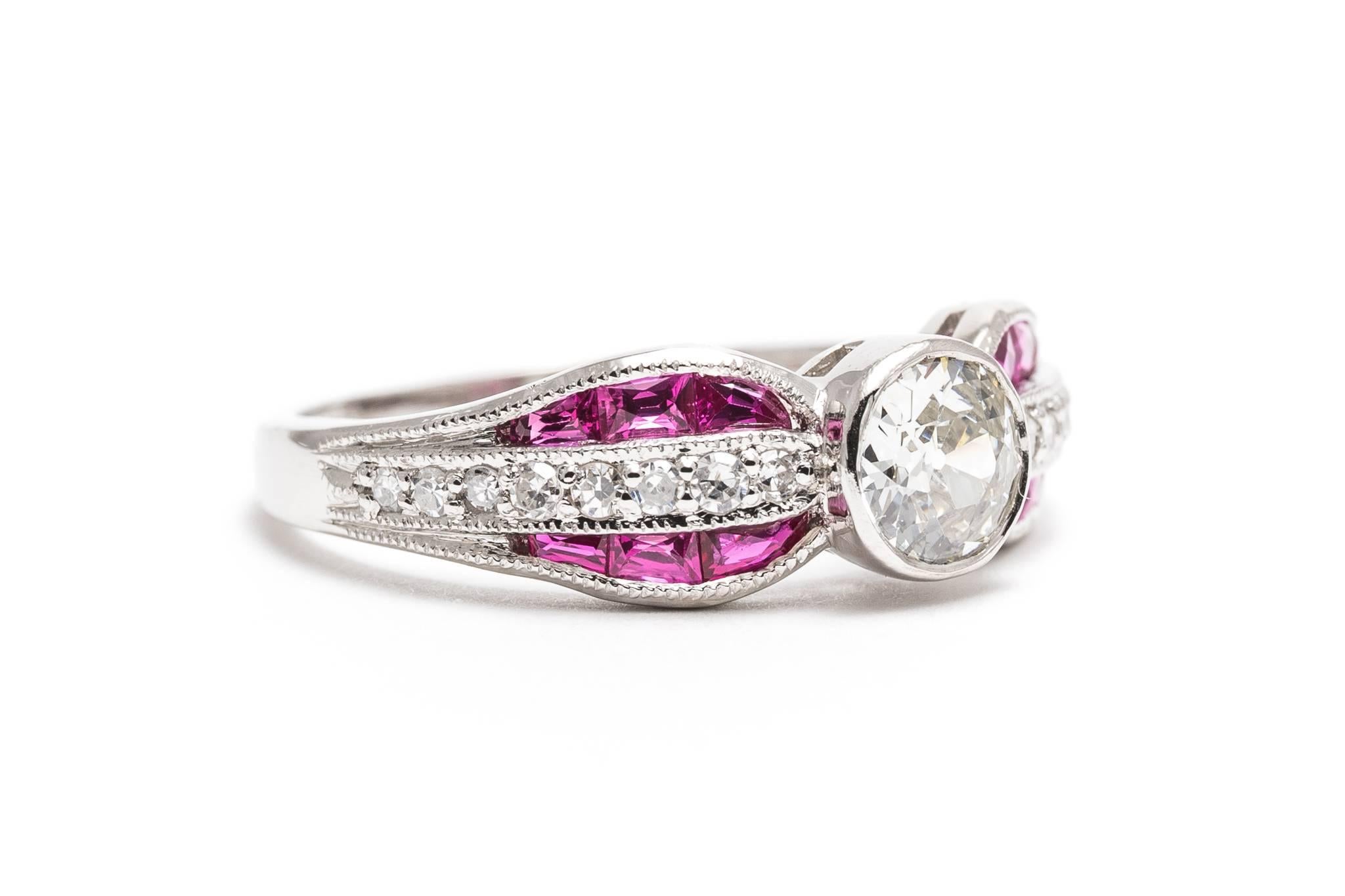 Beacon Hill Jewelers Presents:  

A beautiful bow shaped diamond and ruby ring in luxurious 900 fine platinum. Masterfully hand crafted, this stunning ring features a center bezel set diamond accented by custom cut French cut rubies and sparkling